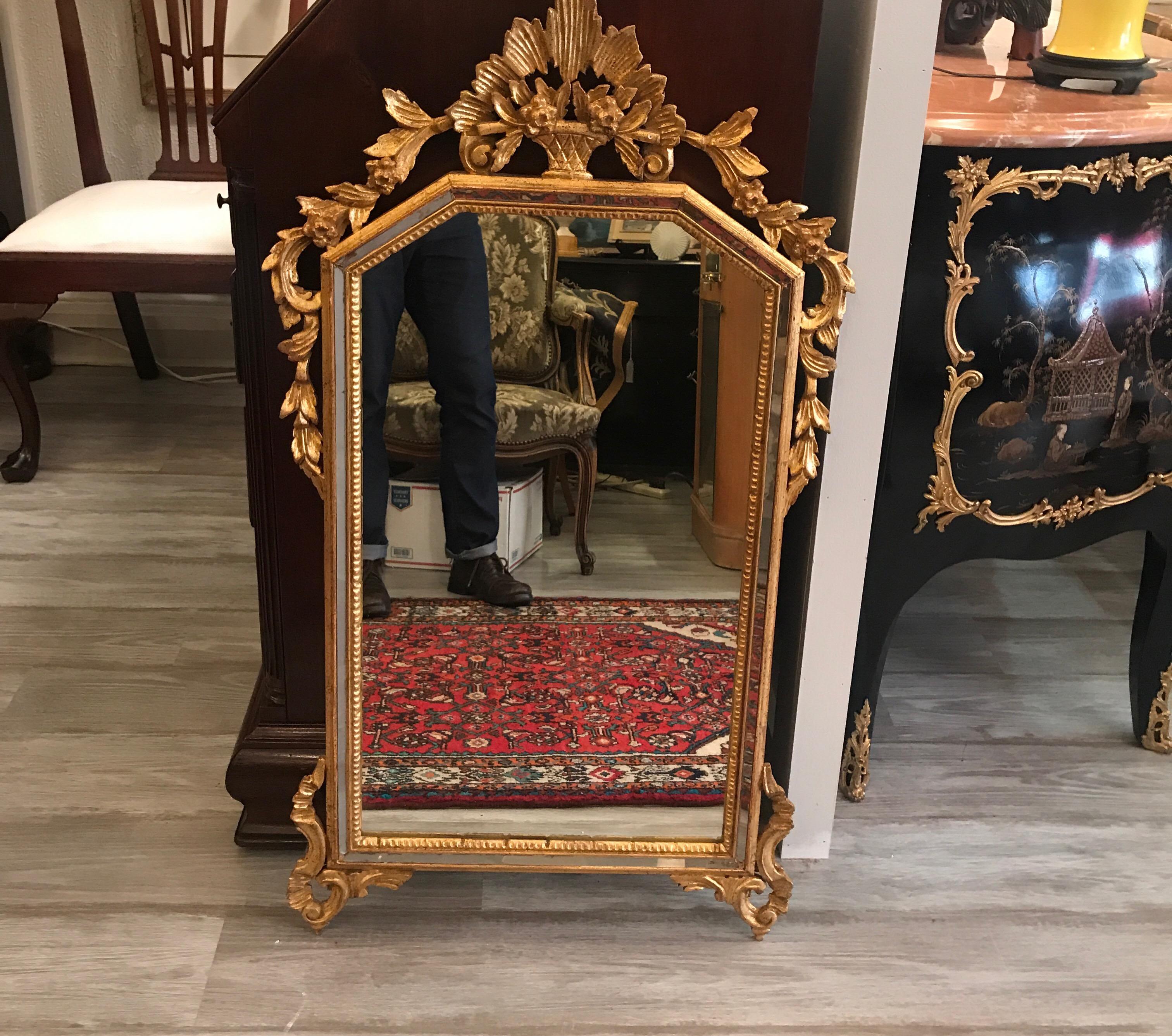 A Louis XV style giltwood mirror with elaborate frame. The intricate pediment with leafy scrolls down the sides with a sliver of mirror inset to the frame. Classically beautiful. The shipping calculator is incorrect, we can have this properly boxed