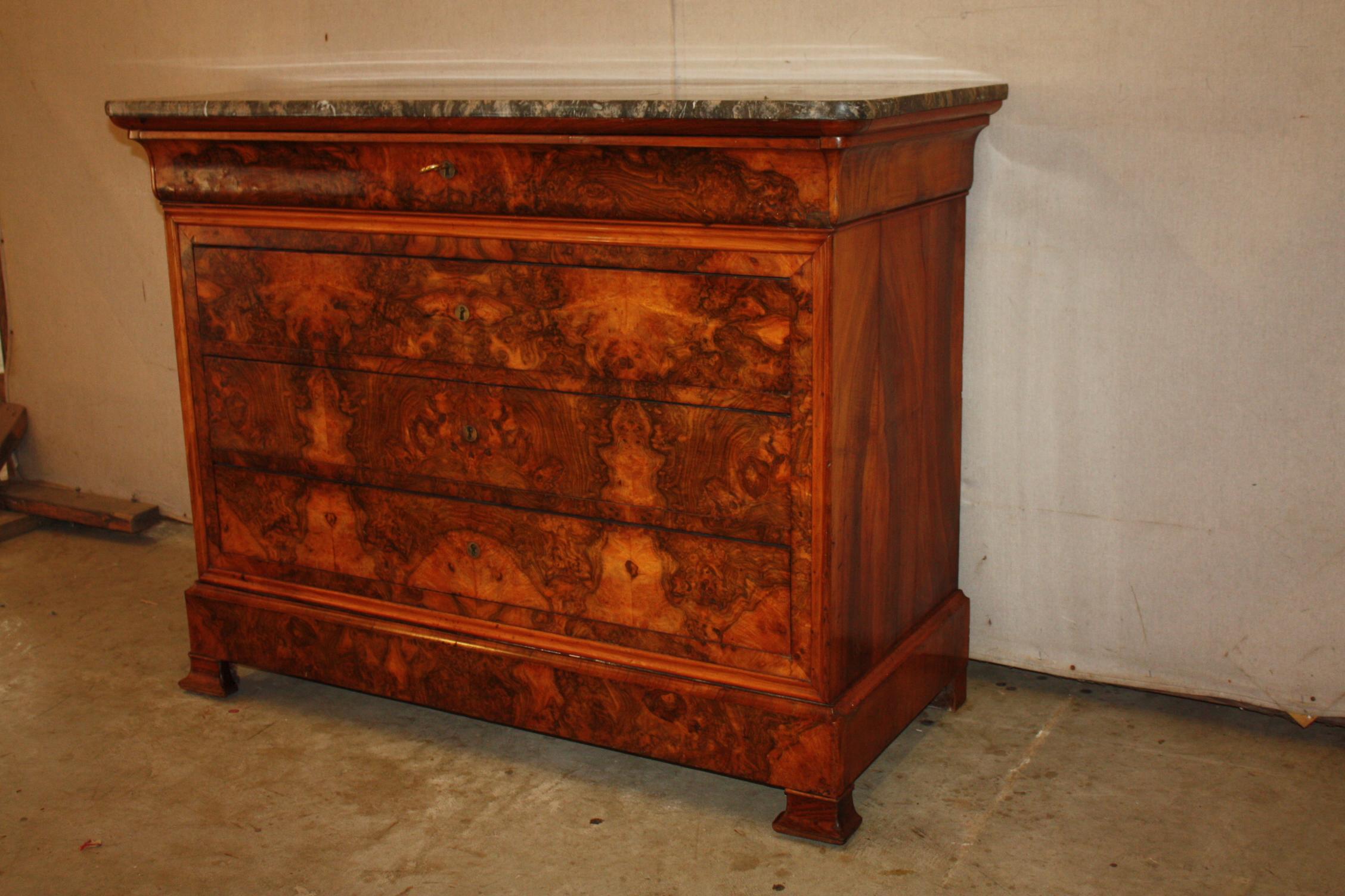 This is a spectacular Louis Phillip walnut commode with a rectangular marble top above and in-curving narrow frieze drawer over three long drawers raised on bracket feet. Beautiful rich patina!