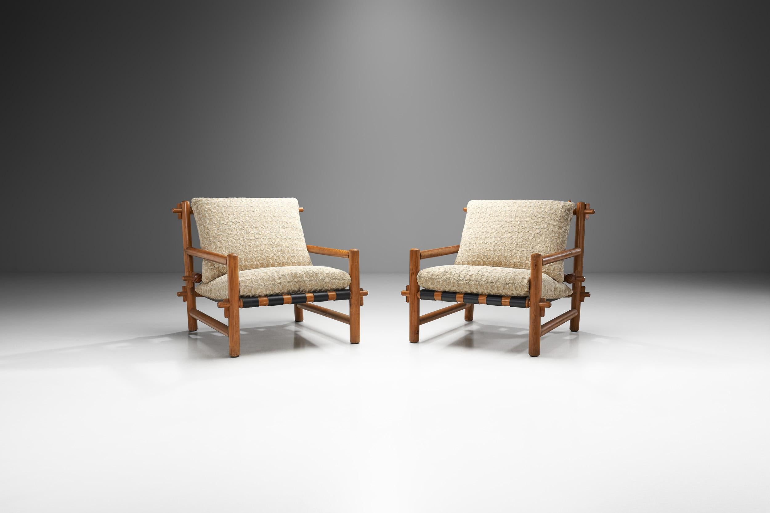 This pair of late mid-century French armchairs combines a visually stunning structural body with an expert construction technique and high-quality materials. In France, the 1960s saw brilliant designers and architects working to create furniture of