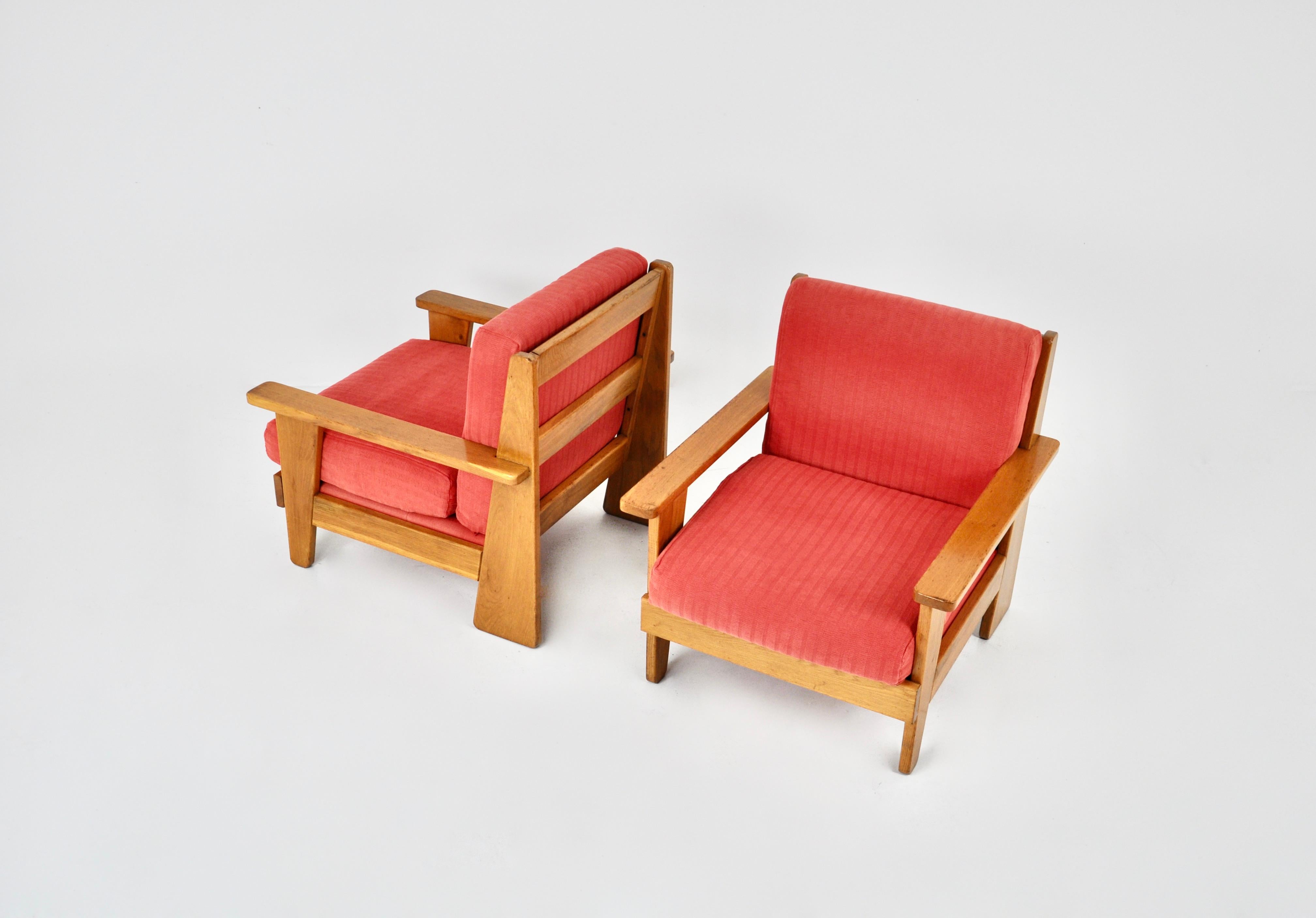 Paire de fauteuils français en tissu rouge et bois. Hauteur du siège : 44 cm. Usure due au temps et à l'âge des fauteuils.
