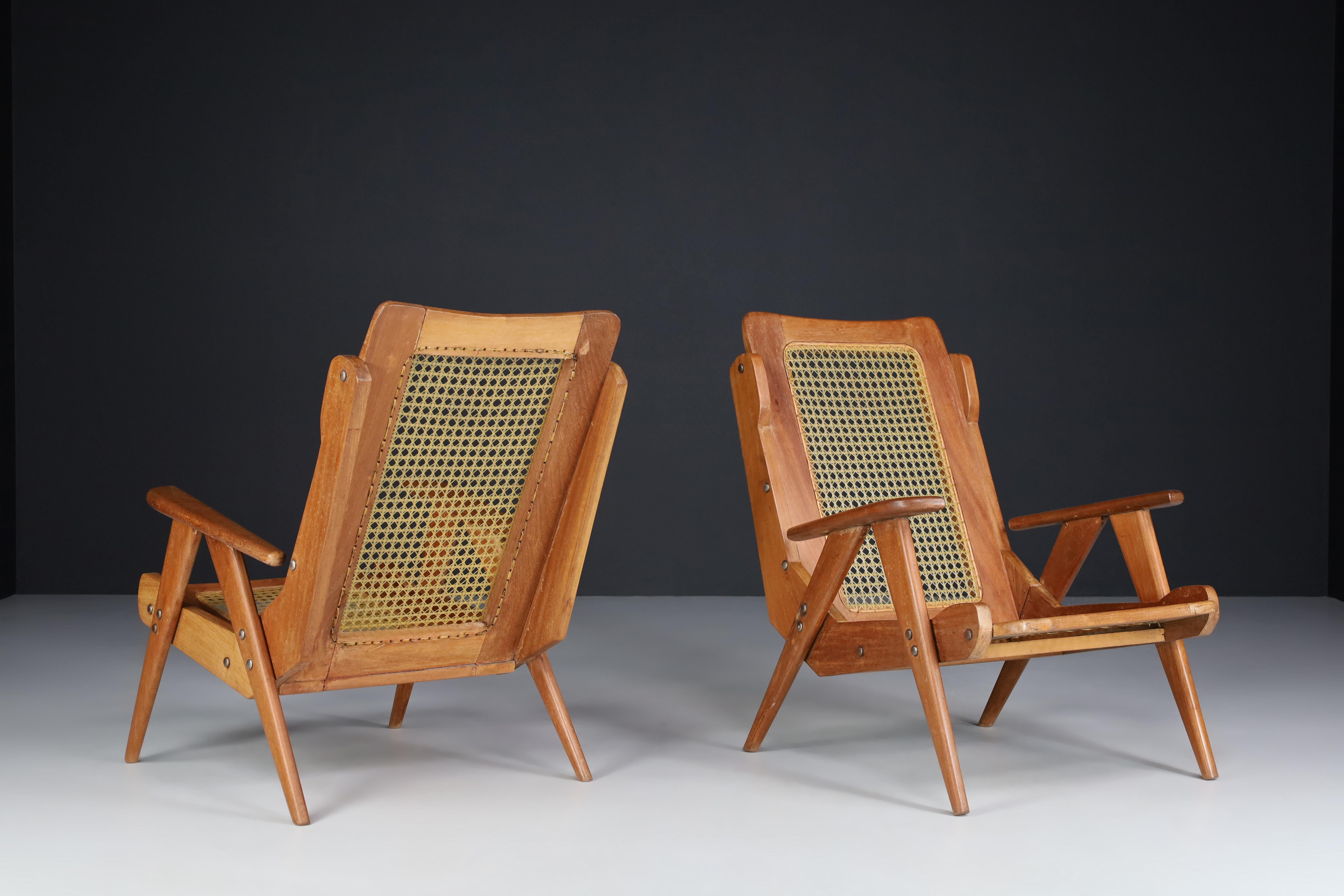 French lounge chairs with teak structure and Webbing , France 1950s

This mid-century French arm chairs / lounge chairs combines a visually stunning structural body with expert caning technique and high-quality materials. From all sides, this
