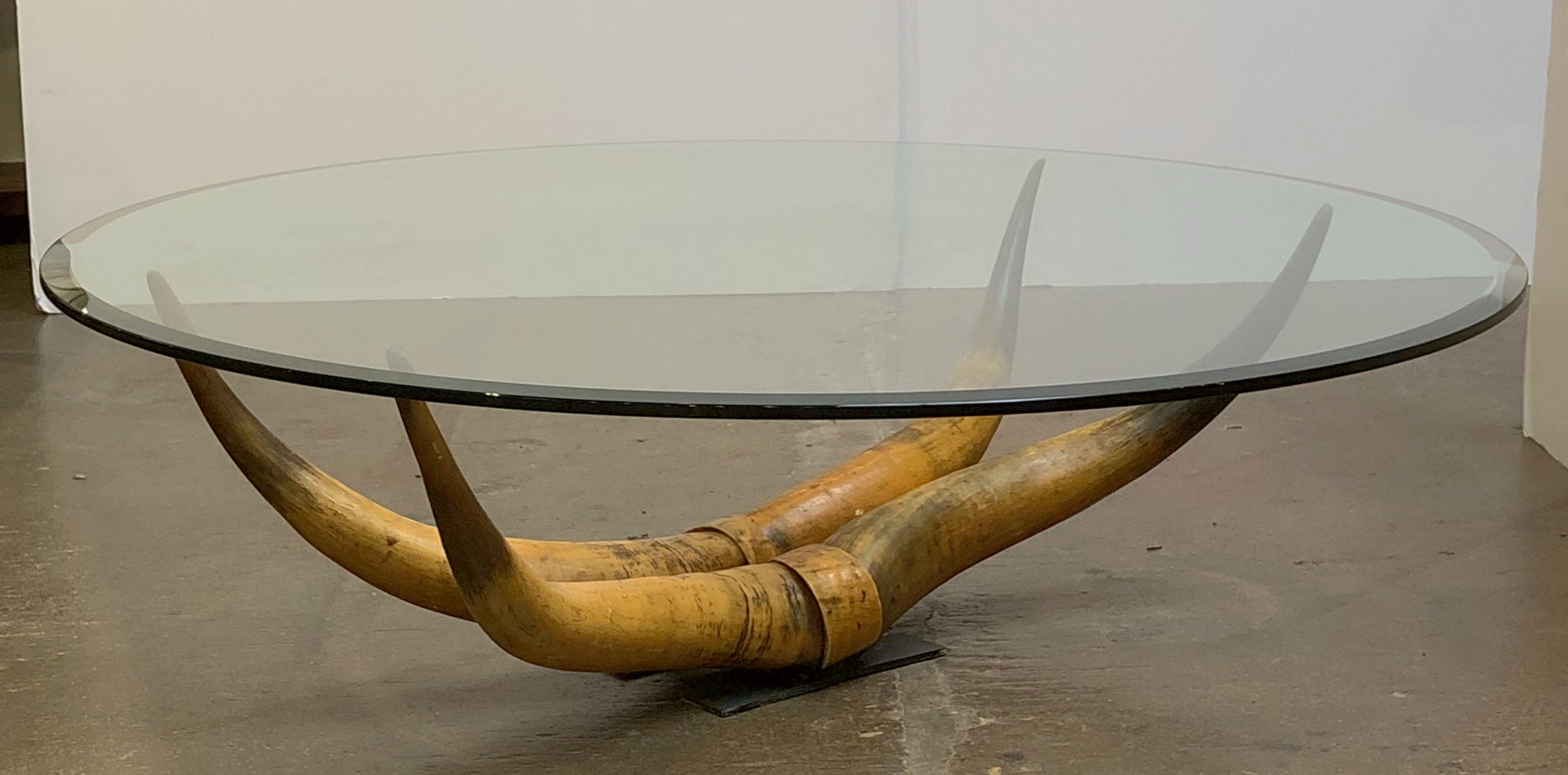 A fine French low table featuring a round or circular beveled glass top set upon a steer Horn rack mounted to a metal plate base.

Perfect for use as a coffee or cocktail table.

Dimensions: Height 14 3/4 inches x diameter 48 inches.