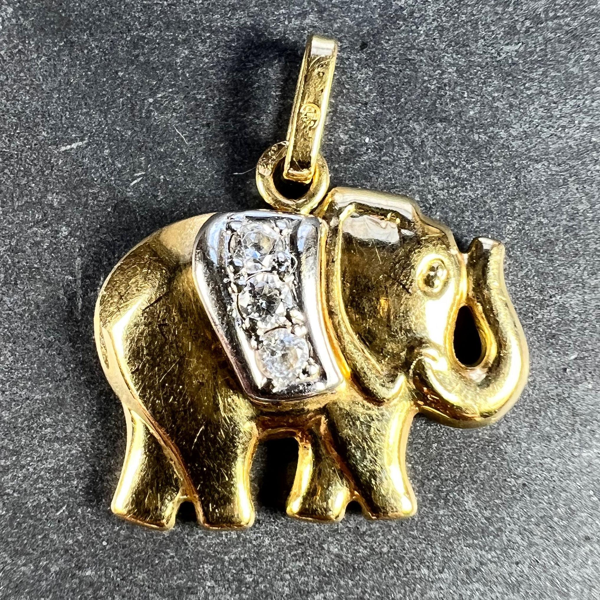 A French 18 karat (18K) yellow and white gold charm pendant designed as a lucky elephant with a diamond blanket over its back. Stamped with the eagle's head for 18 karat gold and French manufacture along with an unknown maker's mark.

Gem