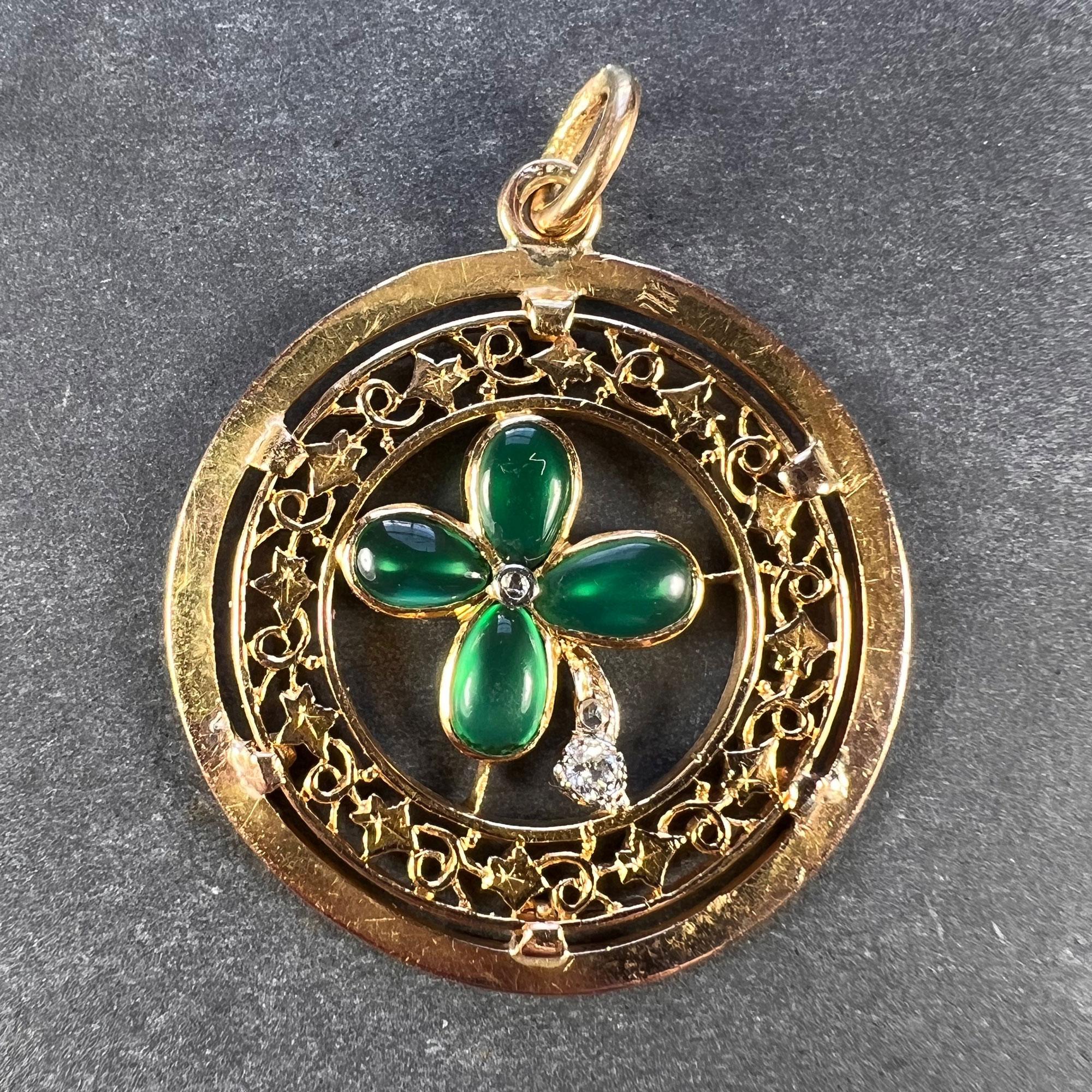 An 18 karat (18K) yellow gold charm pendant designed as a lucky four-leaf clover or shamrock with four cabochon green agate leaves centring a rose cut diamond, and a diamond set stem (total 0.07 carats), within a pierced circular frame of ivy