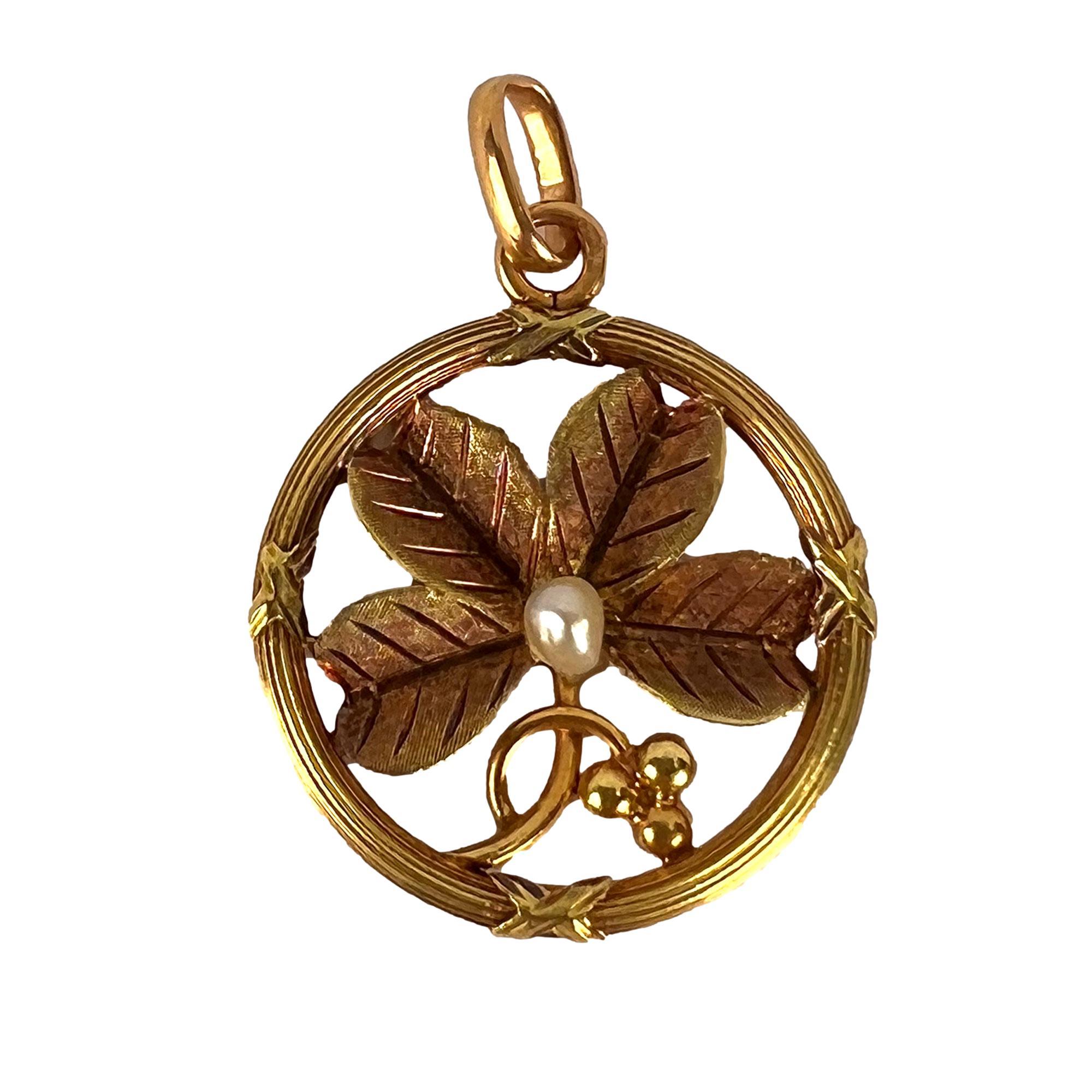An 18 karat (18K) yellow gold charm pendant designed as a four-leaf clover or shamrock with a natural pearl centre within a reeded circular frame. Stamped with the eagle’s head for French manufacture and 18 karat gold.

Dimensions: 2.5 x 2.1 x 0.25