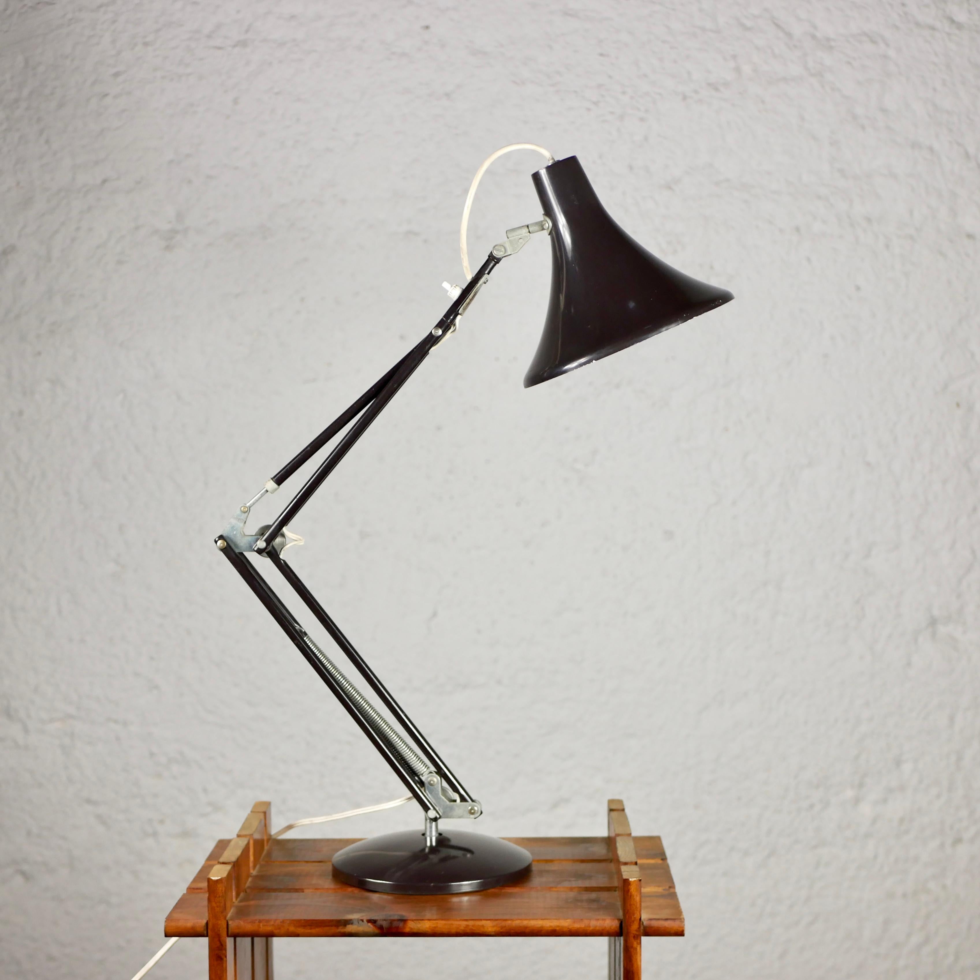 Belle lampe d'architecte classique, très proche de la lampe Luxo en métal laqué brun foncé. Robuste, articulé et pratique. 
Bon état général.
Dimensions : 2 bras de 33cm et 37cm, environ 60cm de hauteur.