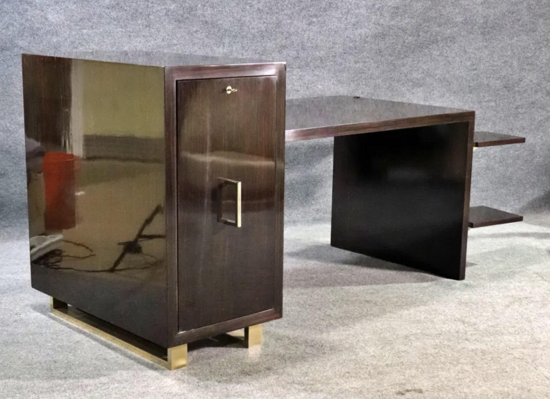 Schöner Art-Déco-Schreibtisch aus lackiertem Makassarholz, mit polierten Bassbeschlägen. Versteckte Schubladen hinter einer langen Seitentür, drehbare Seitentische und eine eingebaute Uhr. Wunderschön konstruiert und gestaltet mit markanter
