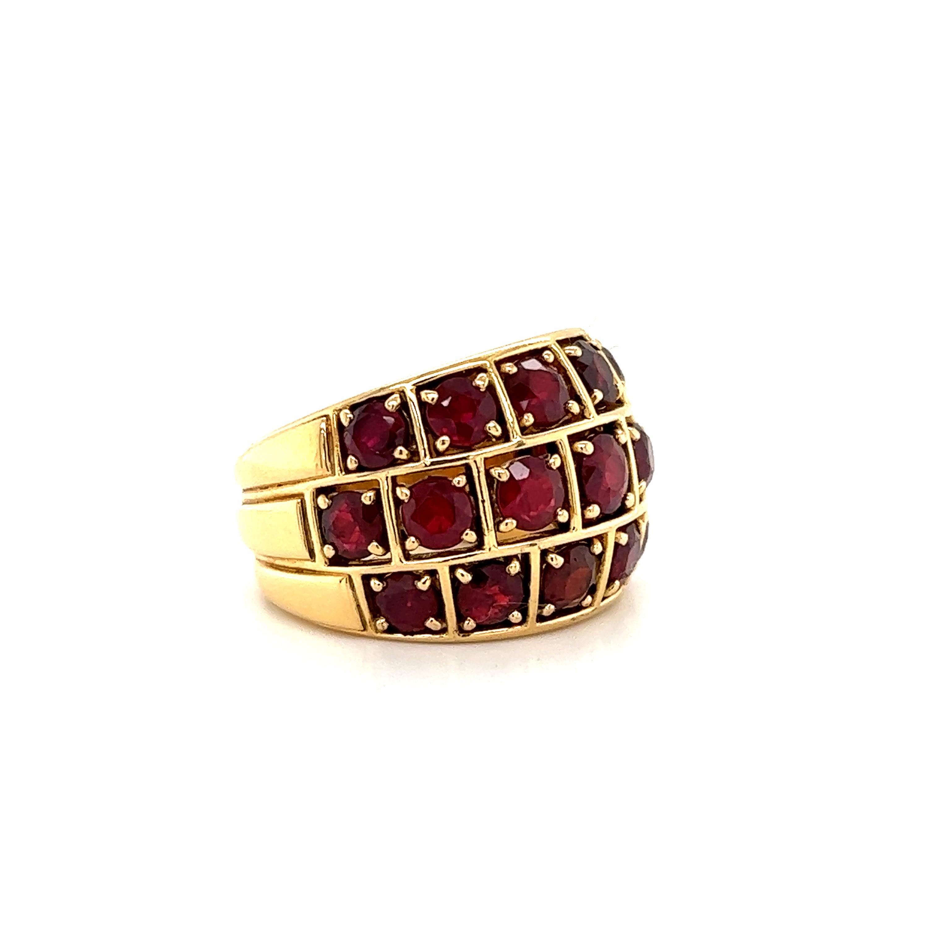 Beautiful ring crafted in 18k yellow gold. The ring is extremely durable and well made. The ring weighs 20 grams and is highlighted with three rows of Burmese rubies that graduate in size across the design. The ruby gemstones display a beautiful