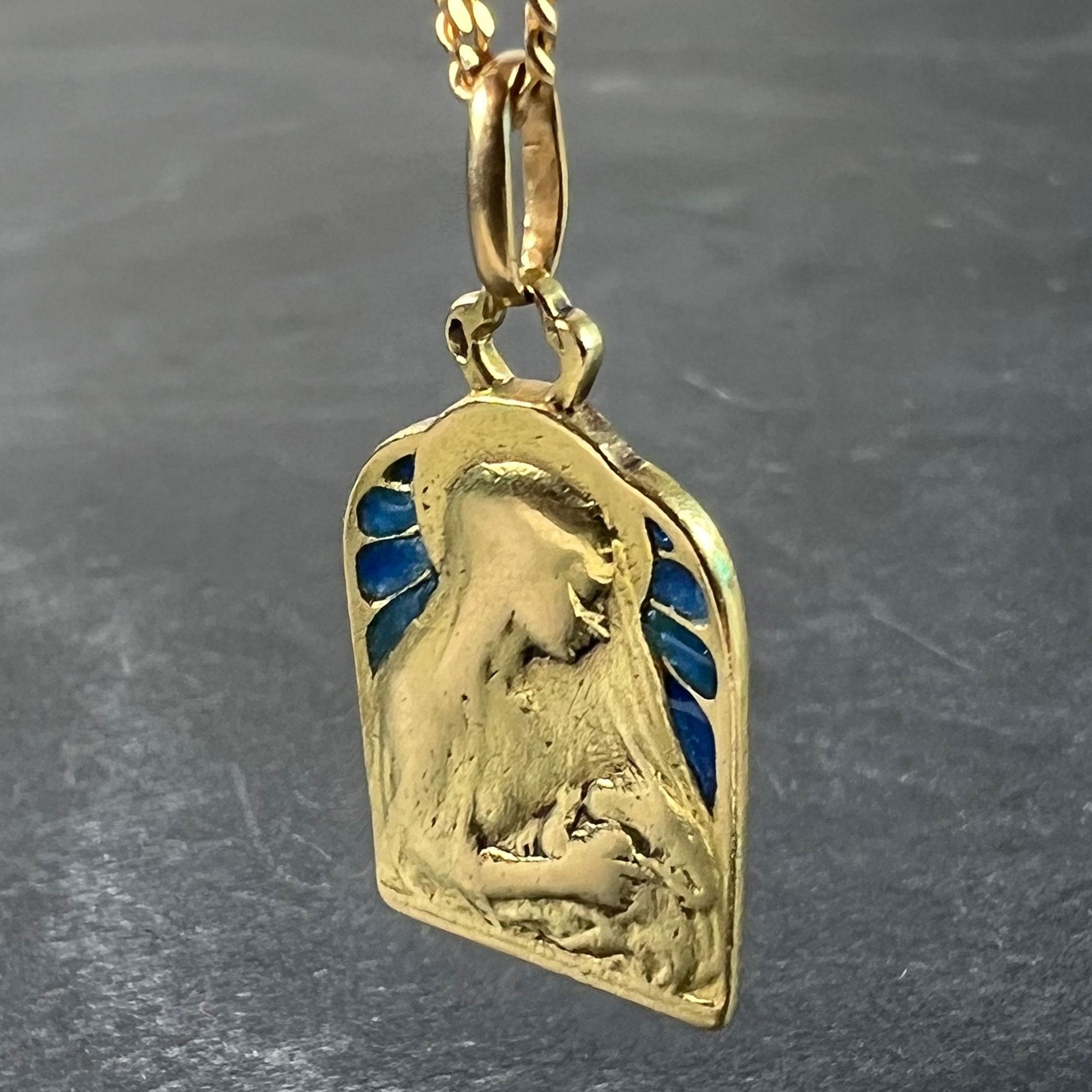 A French 18 karat (18K) yellow gold pendant designed as a medal depicting the Madonna and Child with blue plique-a-jour enamel. Stamped with the eagle's head mark for French manufacture and 18 karat gold, and an unknown maker's mark. Engraved