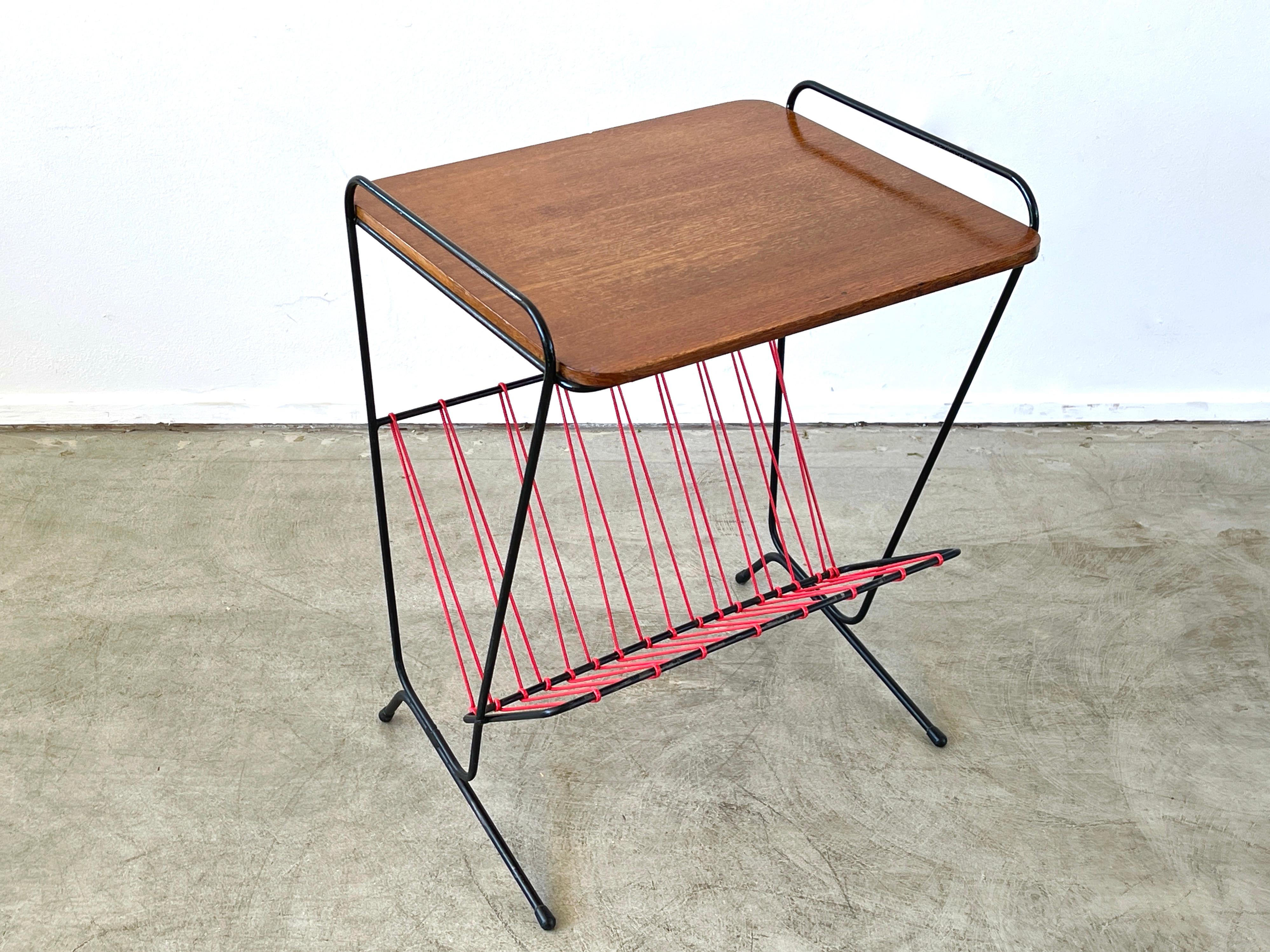 French Iron and wood magazine table with wood top and red cord magazine holder.
Great whimsical shape.