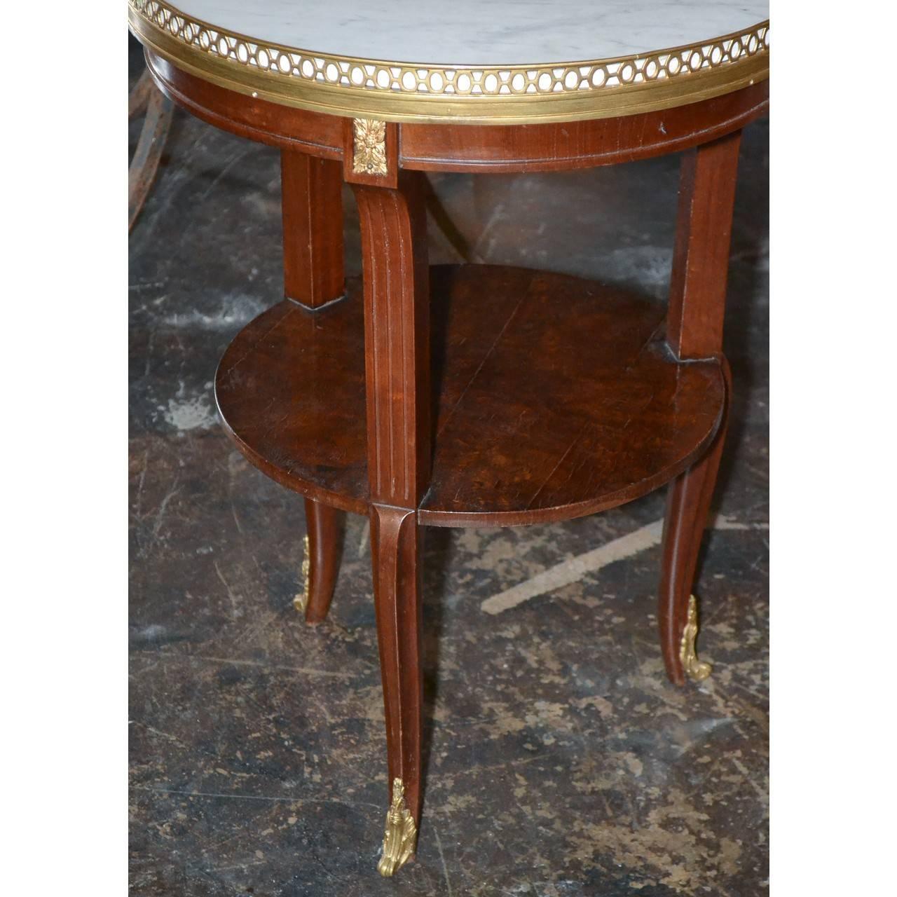 Attractive French Louis XV style mahogany salon, side, or end table with a fine Carrara marble top with filigree brass gallery, bronze accents, lower tier and superbly cast bronze acanthus leaf sabots,

circa 1900.