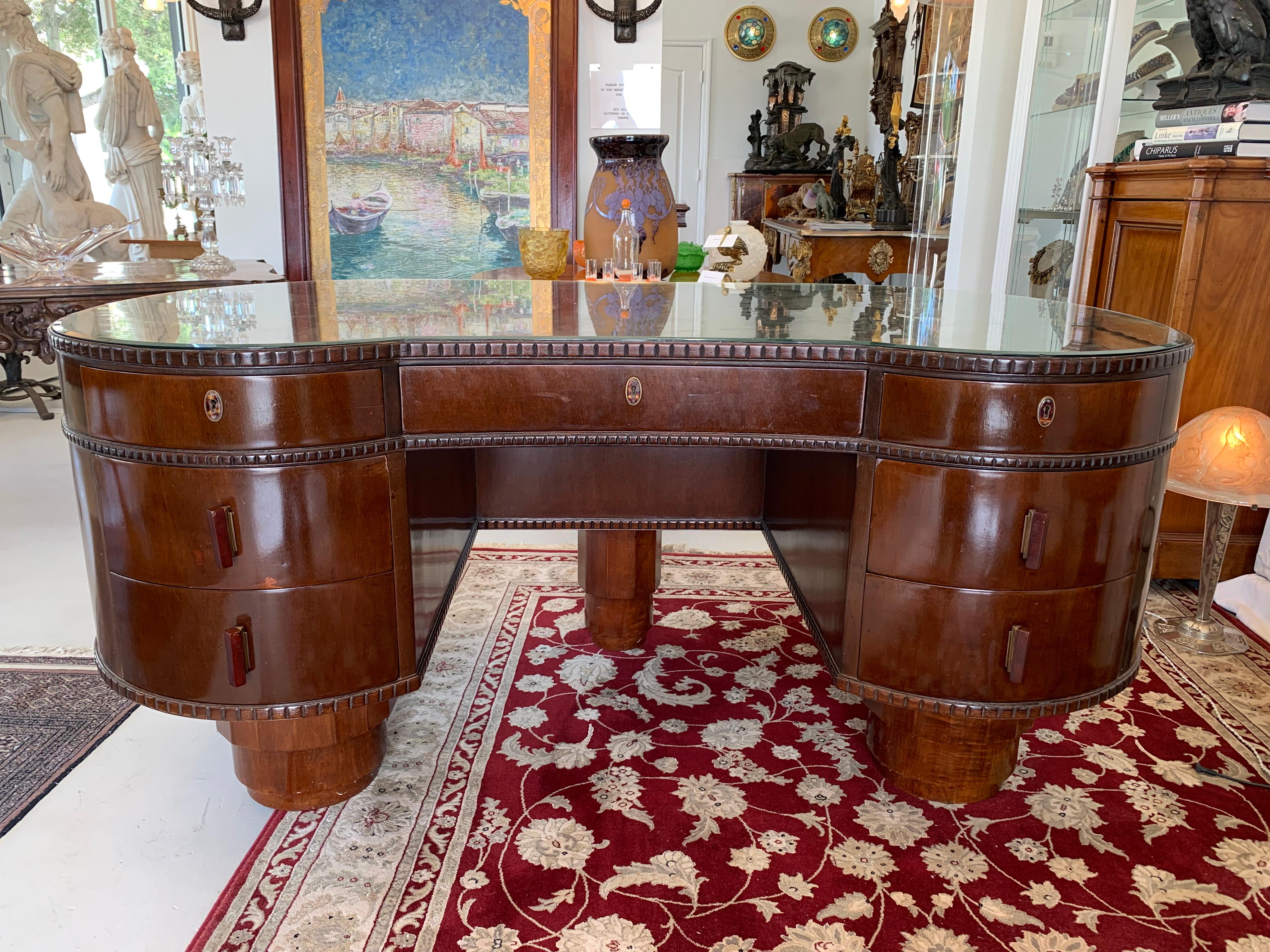 French Art Deco desk circa 1930s with unique shape.
With Bakelite and metal details and its original beveled glass on top supported for 3 barrel legs in the purest Art Deco way.