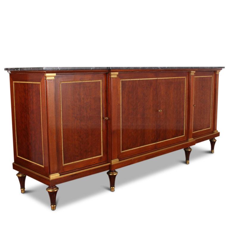 A high quality French mahogany breakfront buffet with fine ormolu mounts and a grey marble top; stamped ‘Rinck’, a Parisian cabinetmaker. Four doors open to reveal adjustable shelving. 

Rinck has been a top cabinet making and architectural firm