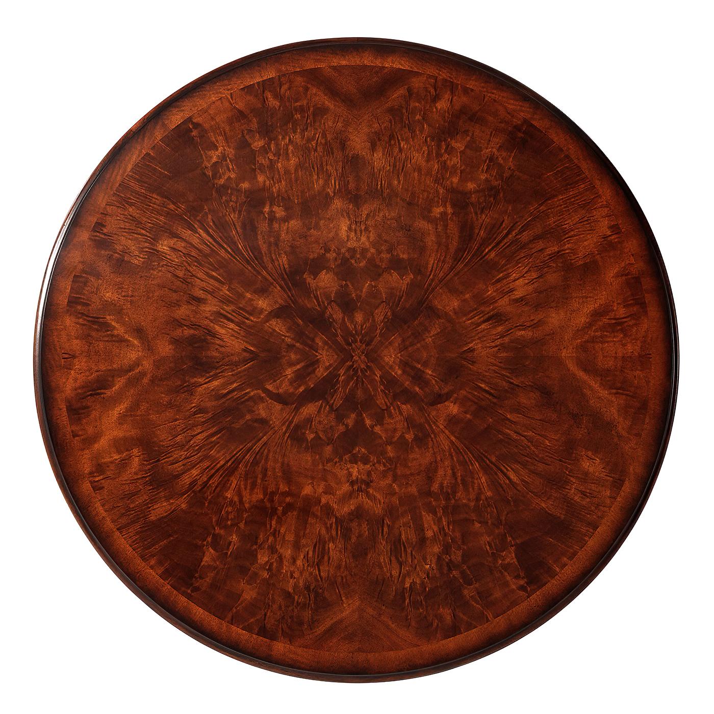 French Louis XI style mahogany center table in the manner of Adam Weisweiler. A flame mahogany crossbanded circular center table, the circular molded edge with two frieze drawers, on turned fluted legs with brass feet joined by a quatrefoil floral