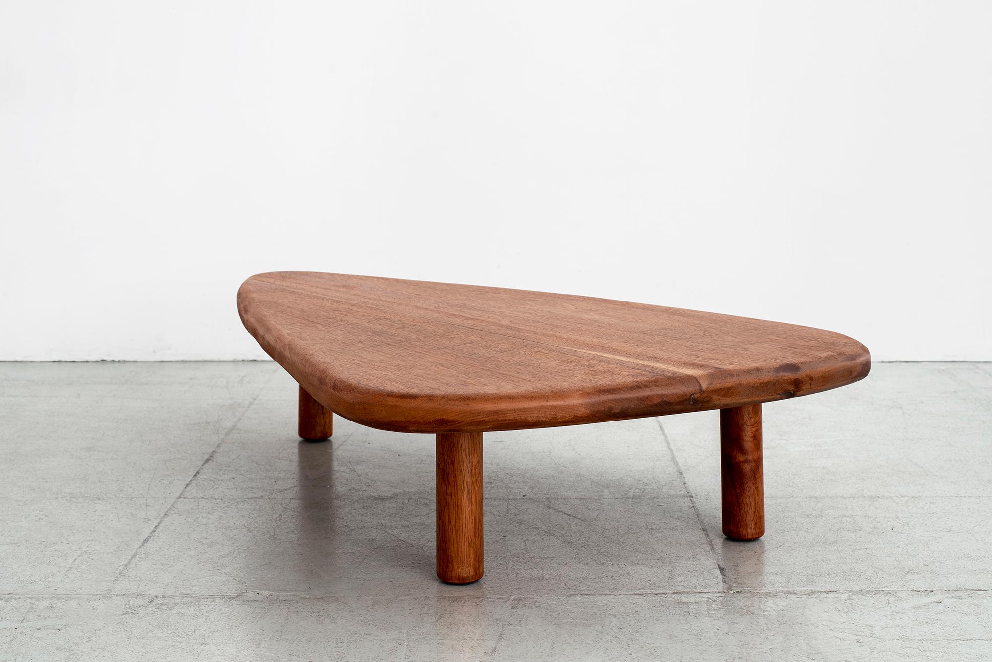 French 1950s freeform coffee table in mahogany wood.
Wonderful guitar pick shape with 3 cylinder legs and radius corners.
Great patina to wood.