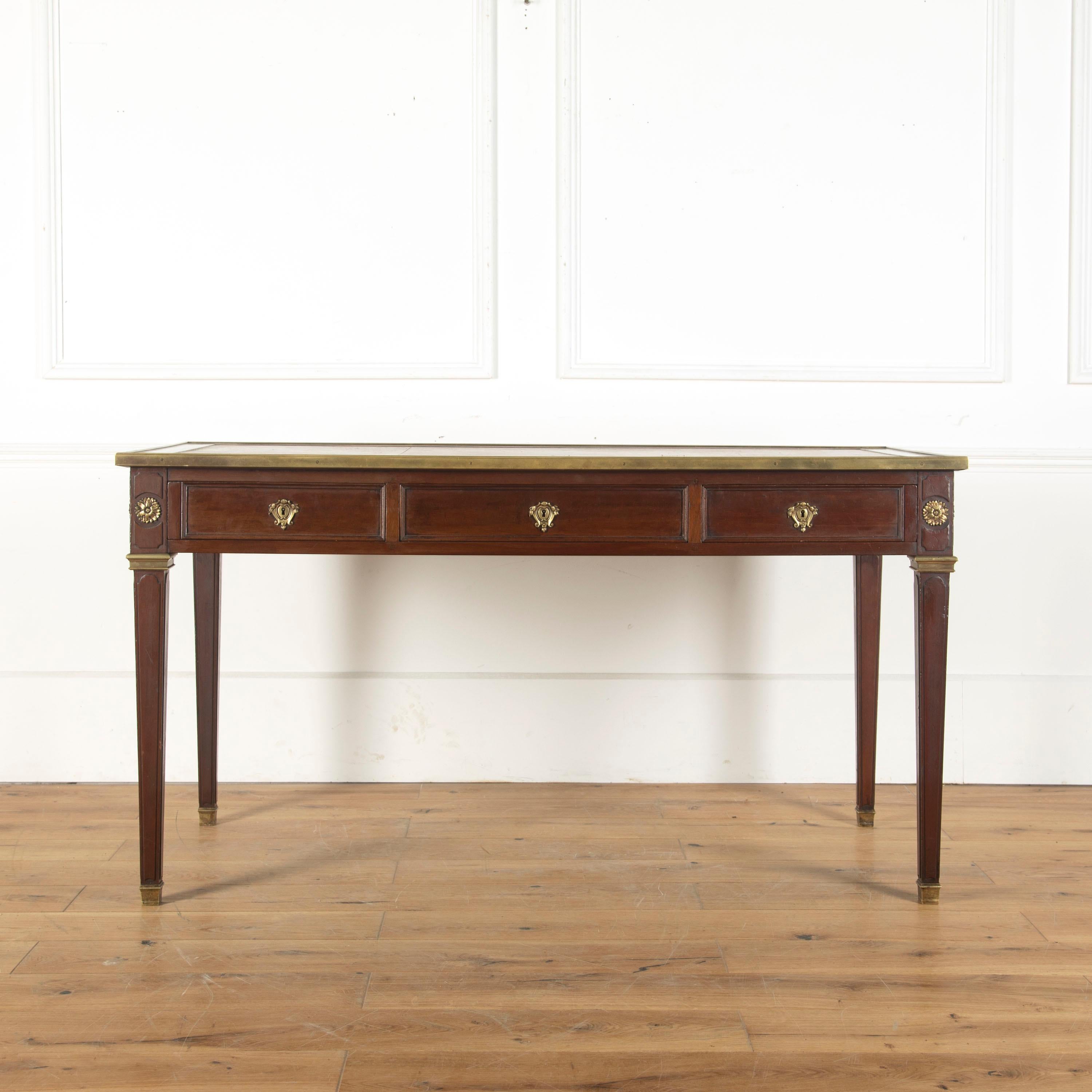 Handsome French mahogany desk in the Louis XVI style, circa 1920.

This beautifully proportioned desk embodies the simple classical lines of French design under Louis XVI. 

Featuring a brass-bound top and lovely high-quality ormolu collars and