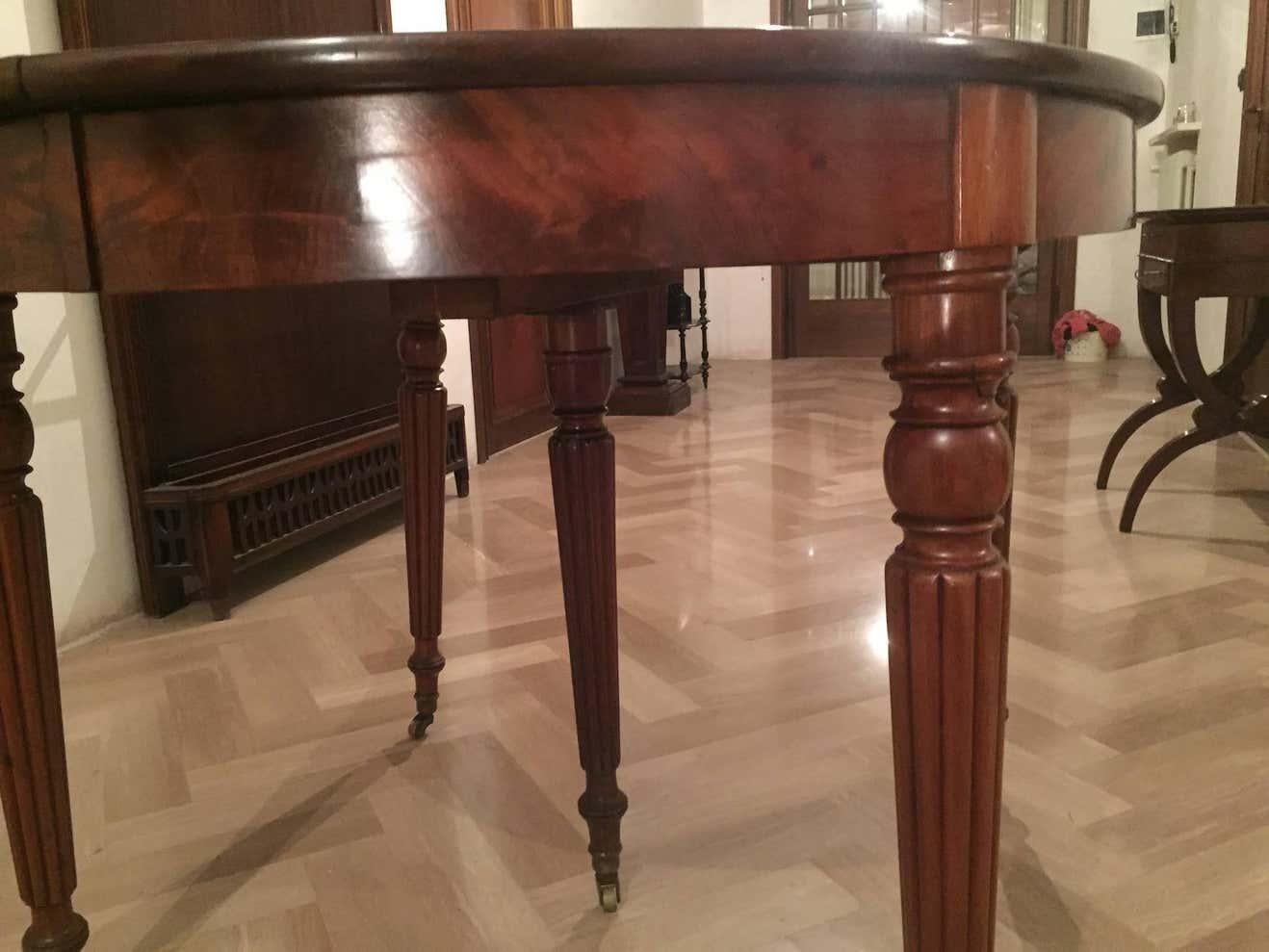 Beautiful French mahogany dining pull-out table Louis Philippe, 1850, the five legs are turned and tapered with balls at the top. The legs have channeled details and sit on original bronze castors.