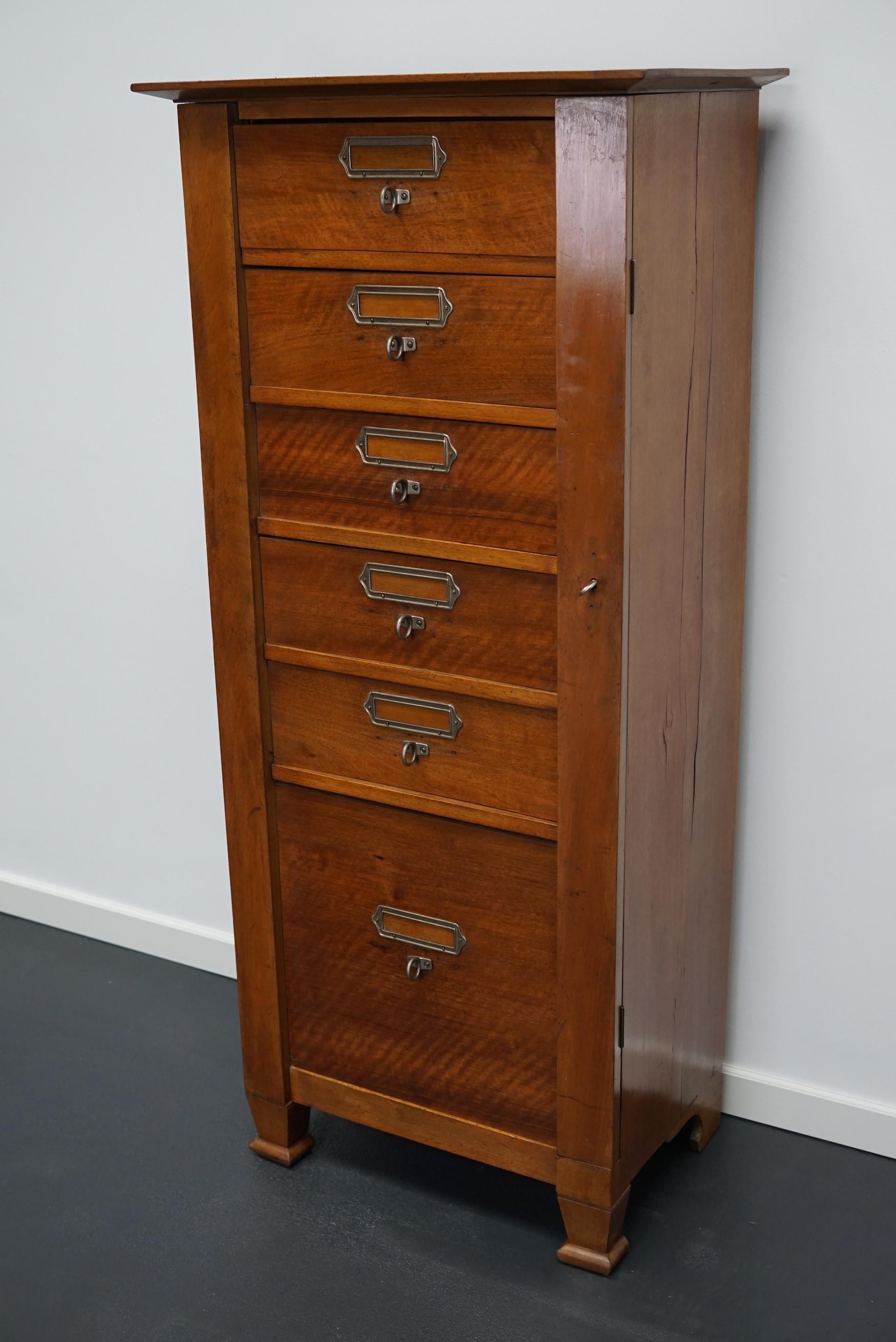 This vintage mahogany bank of drawers dates from the 1930s and was made in France. It features a mahogany frame, drawers with mahogany fronts and metal handles. The drawers can be locked. A small piece of the left back leg is missing.