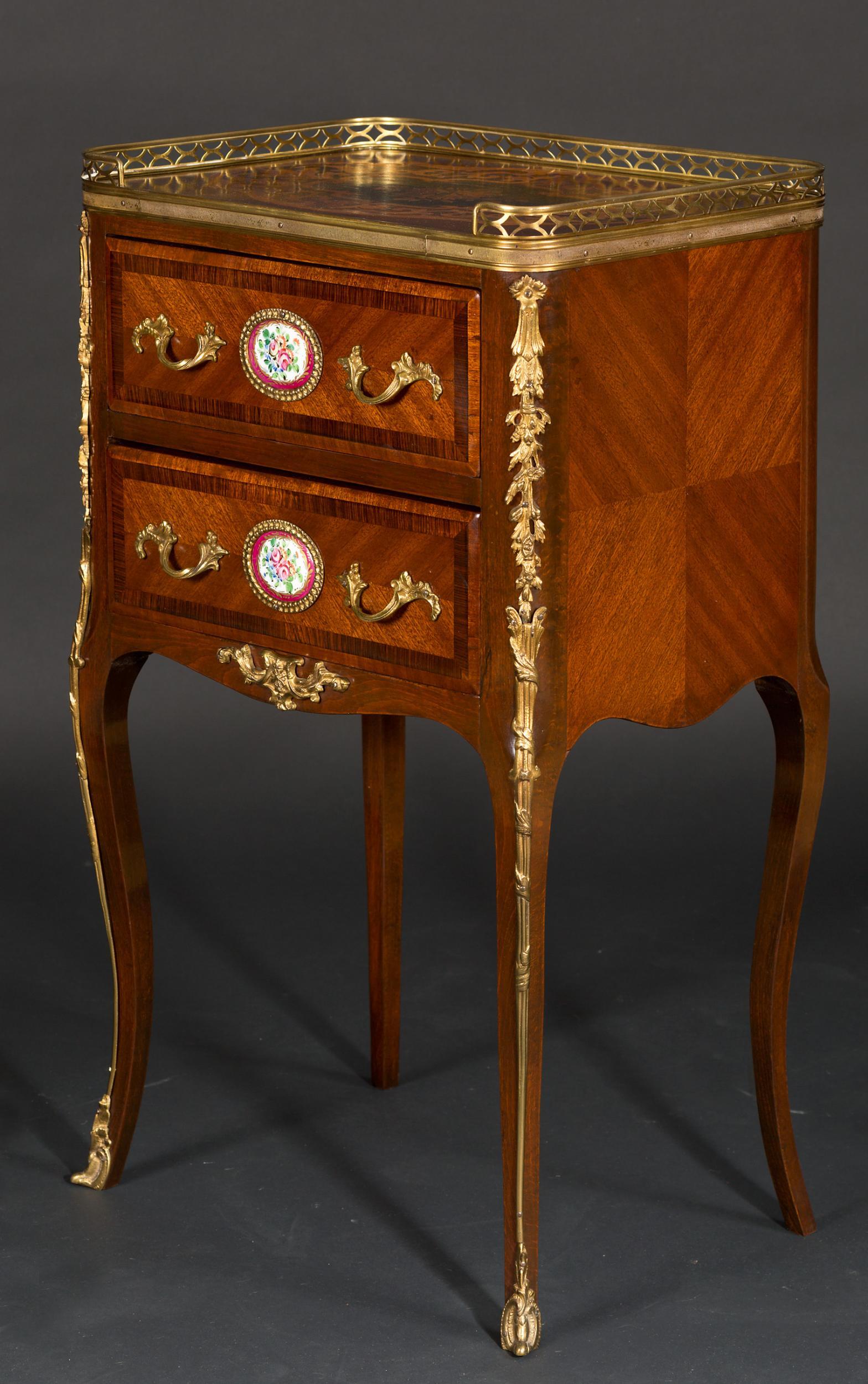 French mahogany table with gallery top, marquetry inlay and two drawers with painted enamel plaques.
c.1890.
