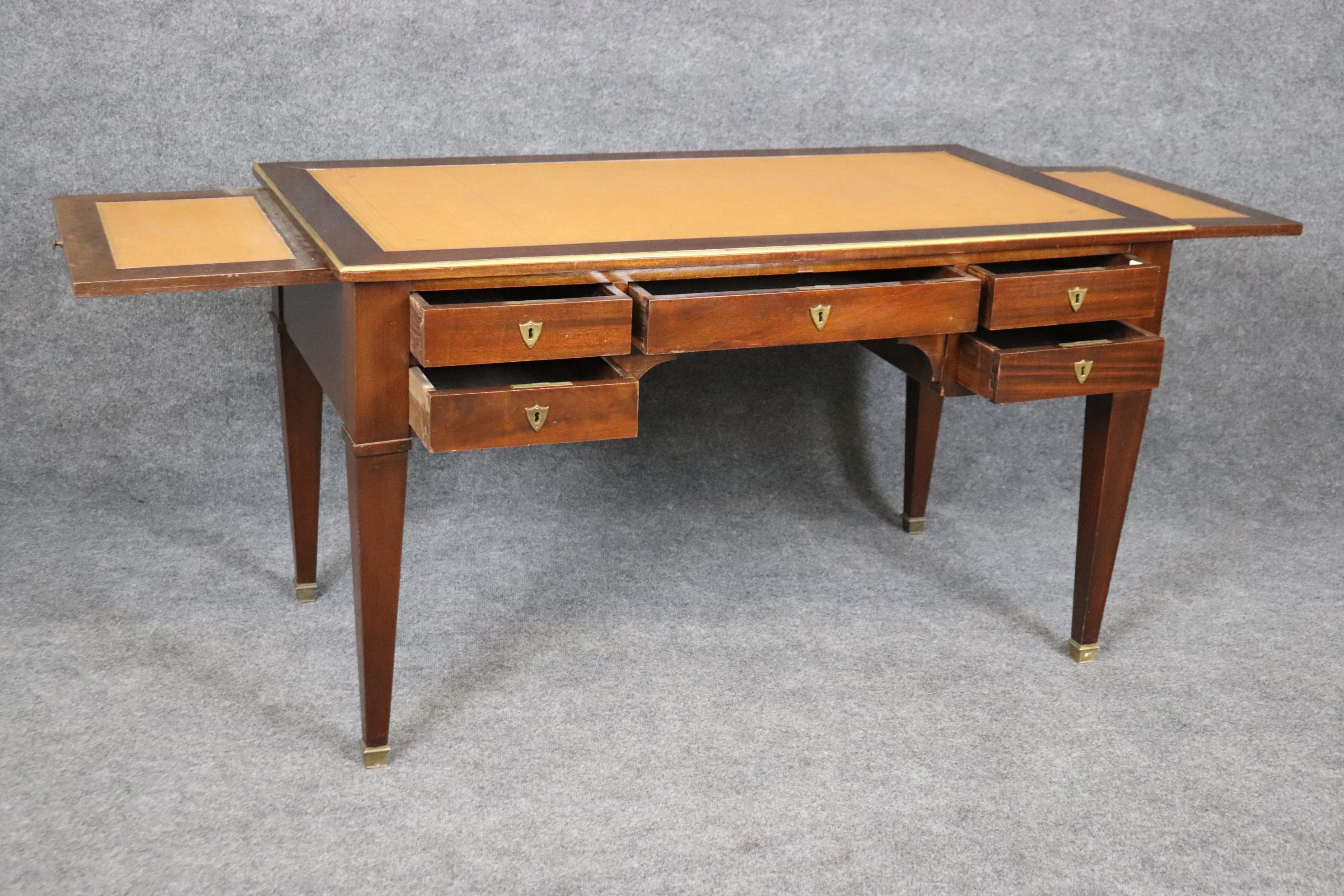 This is a very good French mahogany Directoire desk with bronze ormolu and restrained and simple design. The leather top is in good antique condition with some signs of age and use but nothing crazy or horrid. The desk is a faux partners desk with