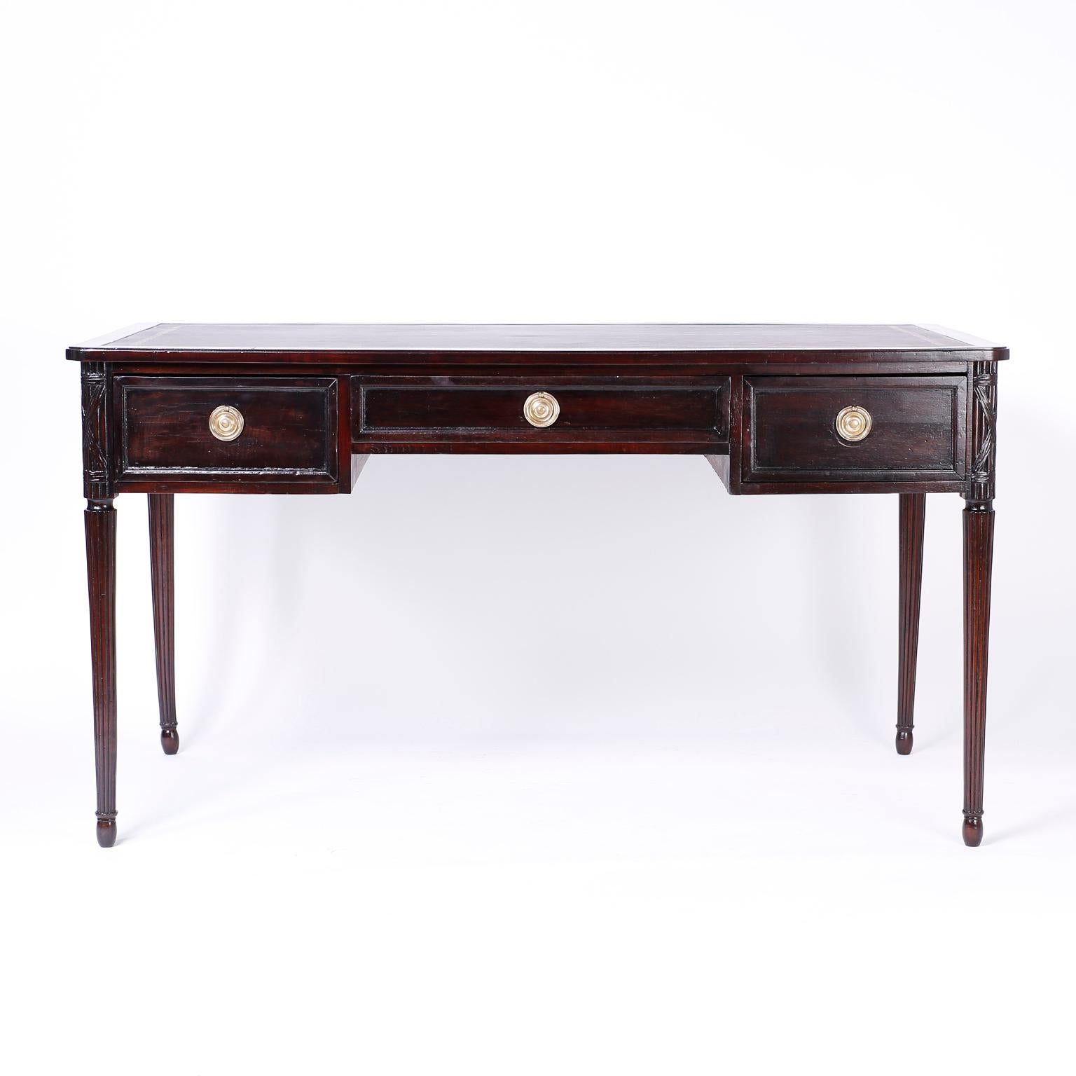 Antique French mahogany writing desk with an ox blood leather top with a gilt border, hand carved corners, paneled drawer fronts and sides and elegant turned and beaded legs.