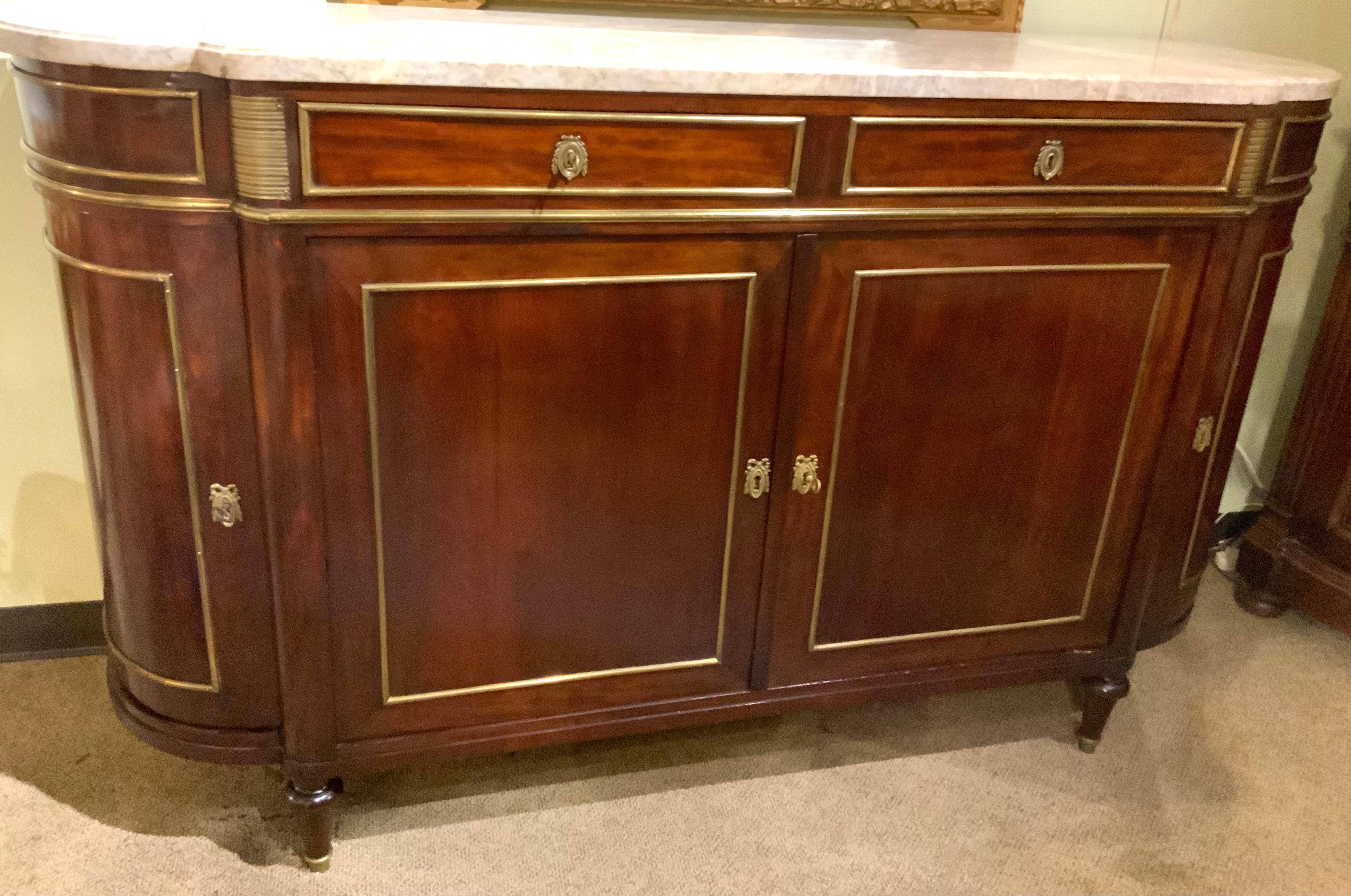 Exceptional quality of mahogany in this piece plus the expert
Cabinetry makes this buffet special. The marble top is a cream colored
Hue with veining in light gray. The sides of this sideboard are gracefully 
Curved. It has one shelf for storage