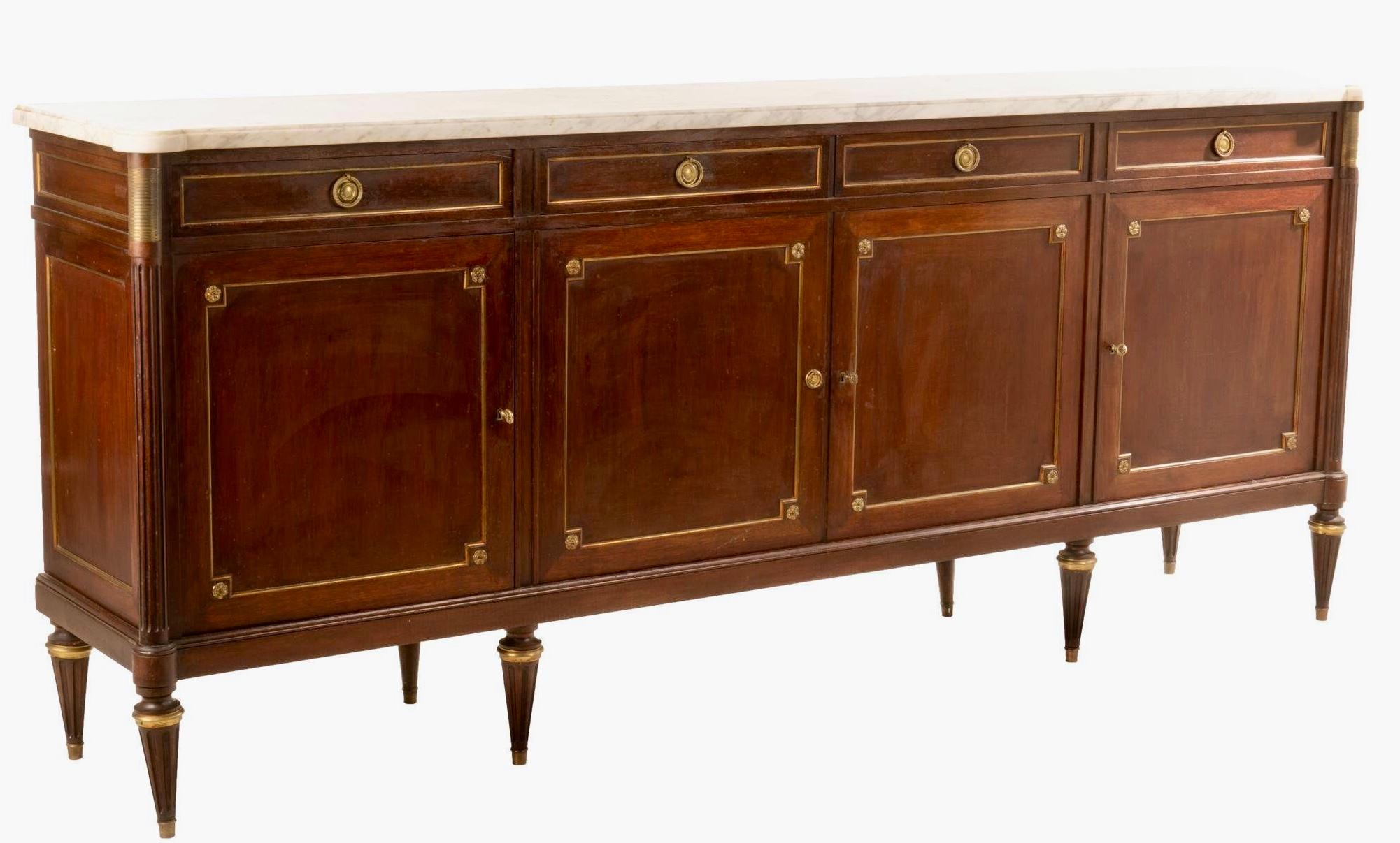 Monumental Louis XVI style walnut enfilade, having marble top over four lined drawers and cabinets leading to interior shelf storage, featuring brass rosette hardware rising on tapered legs ending in brass sabots.