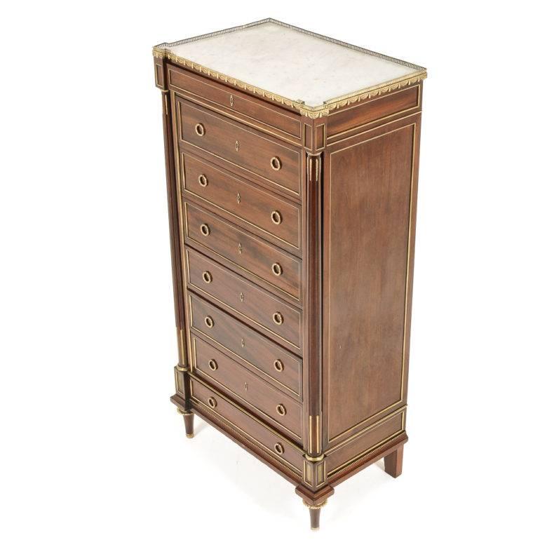 A late 19th century French mahogany semainier with brass details and a marble top with a delightful brass gallery edge, circa 1890.

 