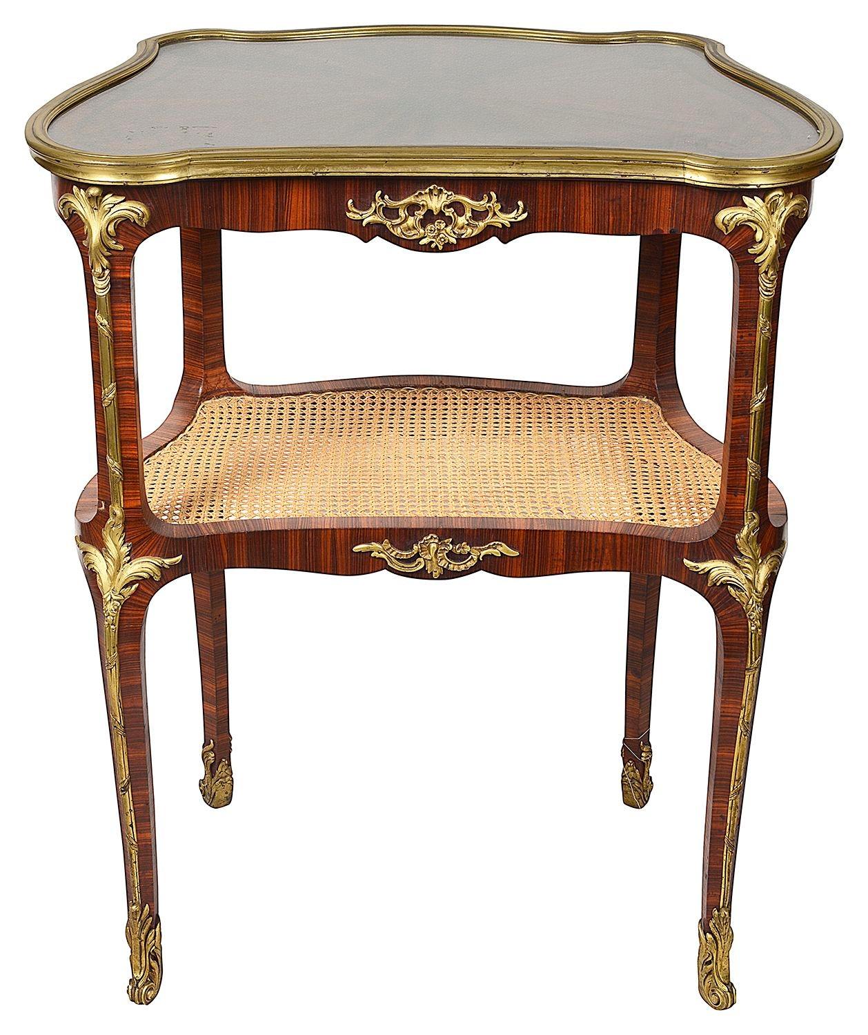 Très belle étagère à deux niveaux en acajou de la fin du XIXe siècle, avec un magnifique plateau en placage segmenté et rayonné, des montures en bronze doré et un sous-étage en rotin, le tout reposant sur des pieds en bronze doré à volutes.

Lot 82