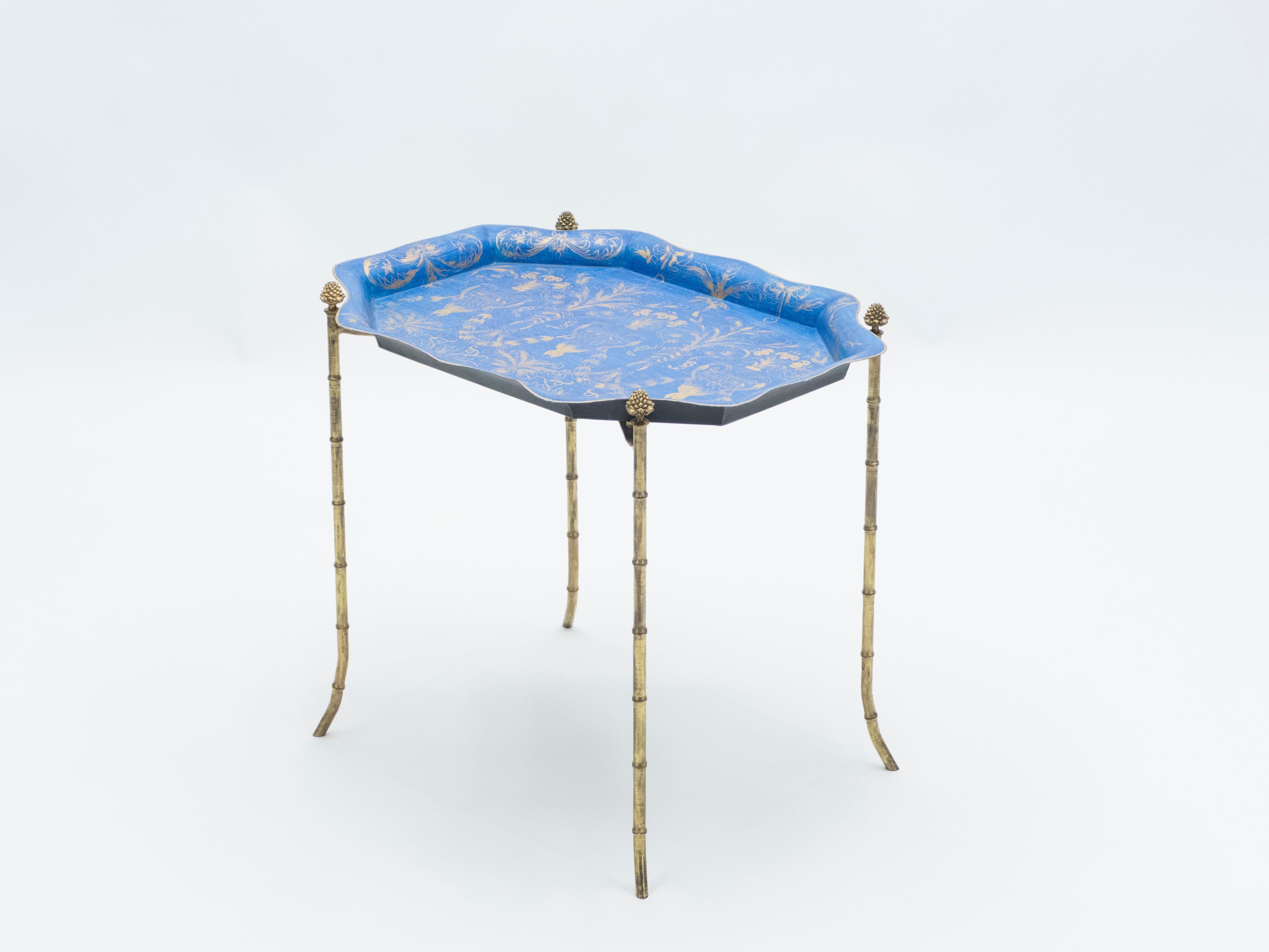 This Maison Baguès Paris tray table is a rare and unique piece from the 1960s. This table features typical french neoclassical pine cones, and beautiful old patina bronze bamboo feet. The tray is in royal blue painted iron with rich golden drawing