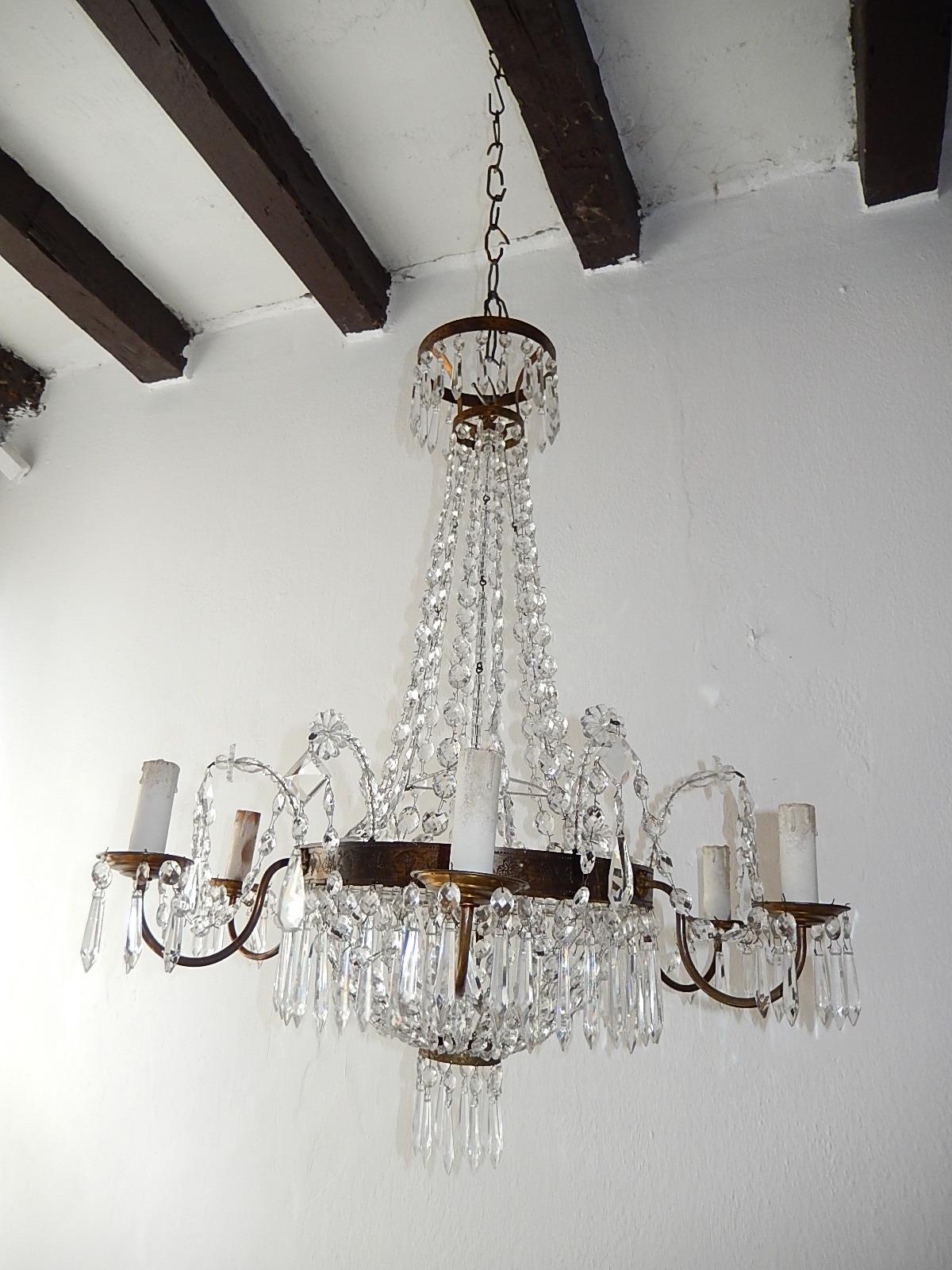Housing six lights. Crystal prisms throughout with a dome bottom and swags of crystals each hand tied. Marked inside. Floret beading projecting out that are detachable. Original chain and canopy still intact. Re-wired and ready to hang. Free