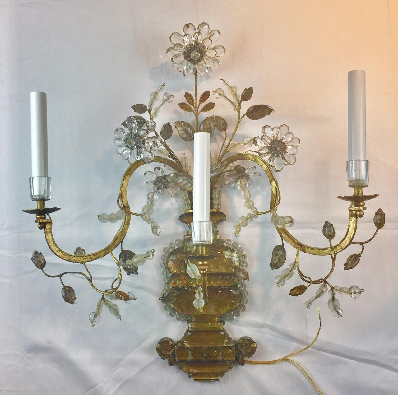This whimsical design of crystal bouquets set in crystal and bronze urns is representative of the poetry and craftmanship of Maison Baguès. Gilt bronze and cut rock crystal 3-light wall sconces of superb quality, with a central carved rock crystal