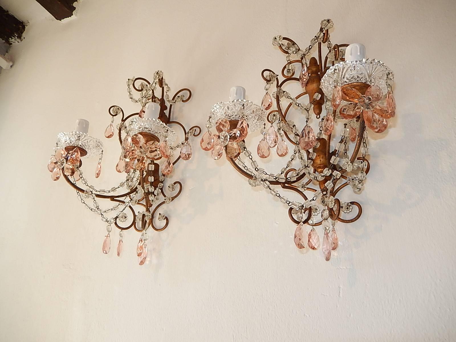 Will be rewired with appropriate sockets for country and ready to hang. Housing two lights, sitting in crystal bobeches dripping with pink crystal prisms. Pink crystal prisms flowers and swags of macaroni beads. Giltwood back on top and bottom. Free