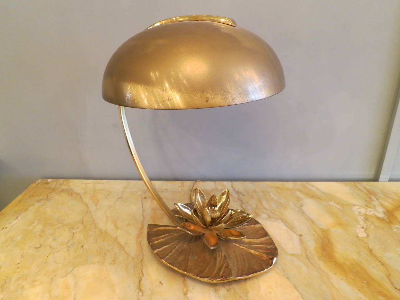 An unusual table lamp by Maison Charles in bronze and brass. With a canopy shade and lily pad base. Canopy shade has some tarnish/patina from age; however this can be polished out if required. Signed Charles, France.