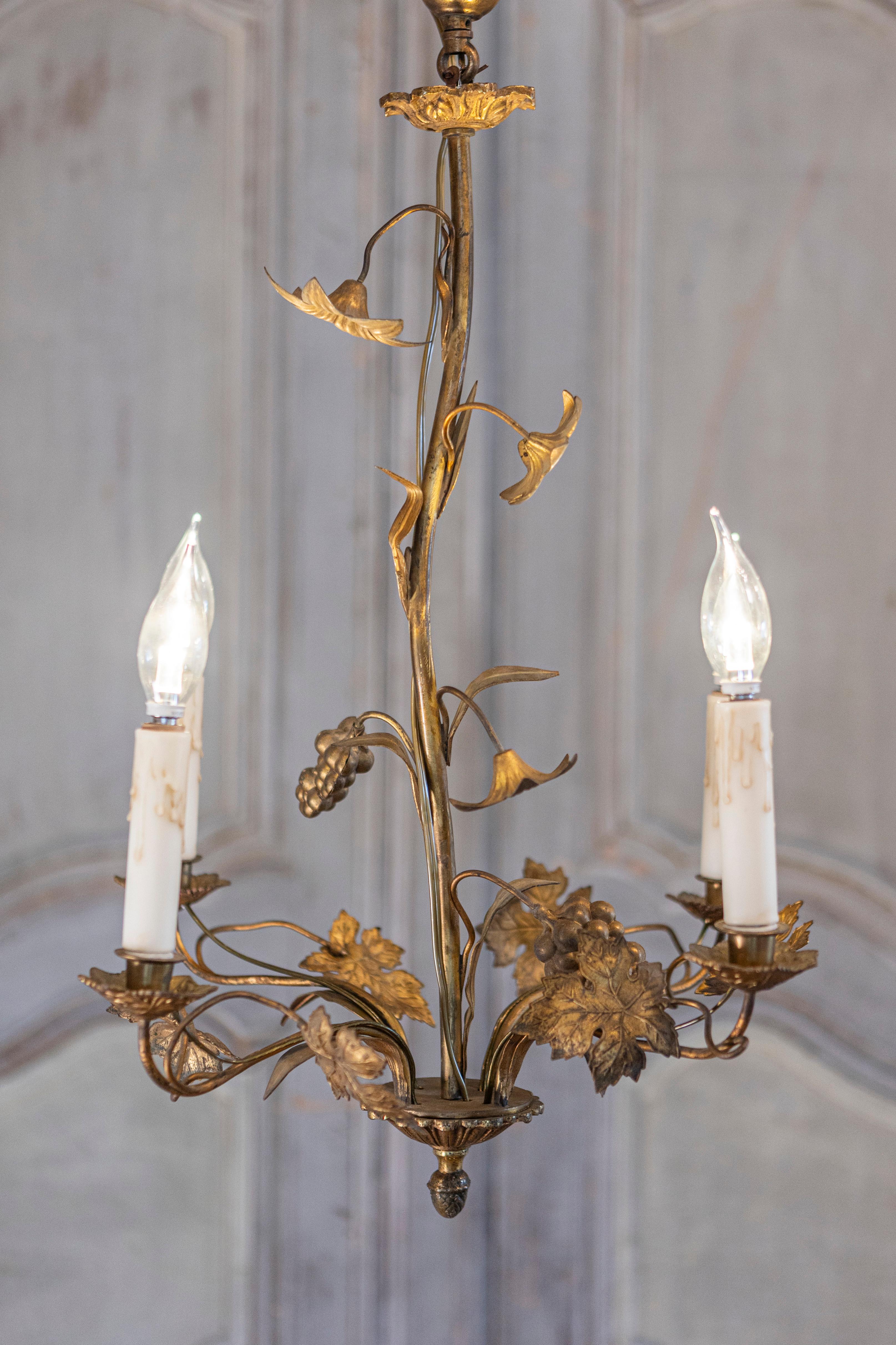 A French Maison Charles inspired gilt metal chandelier from the 20th century with floral and foliage décor. This French Maison Charles inspired gilt metal chandelier from the 20th century captures the essence of elegance with its exquisite floral