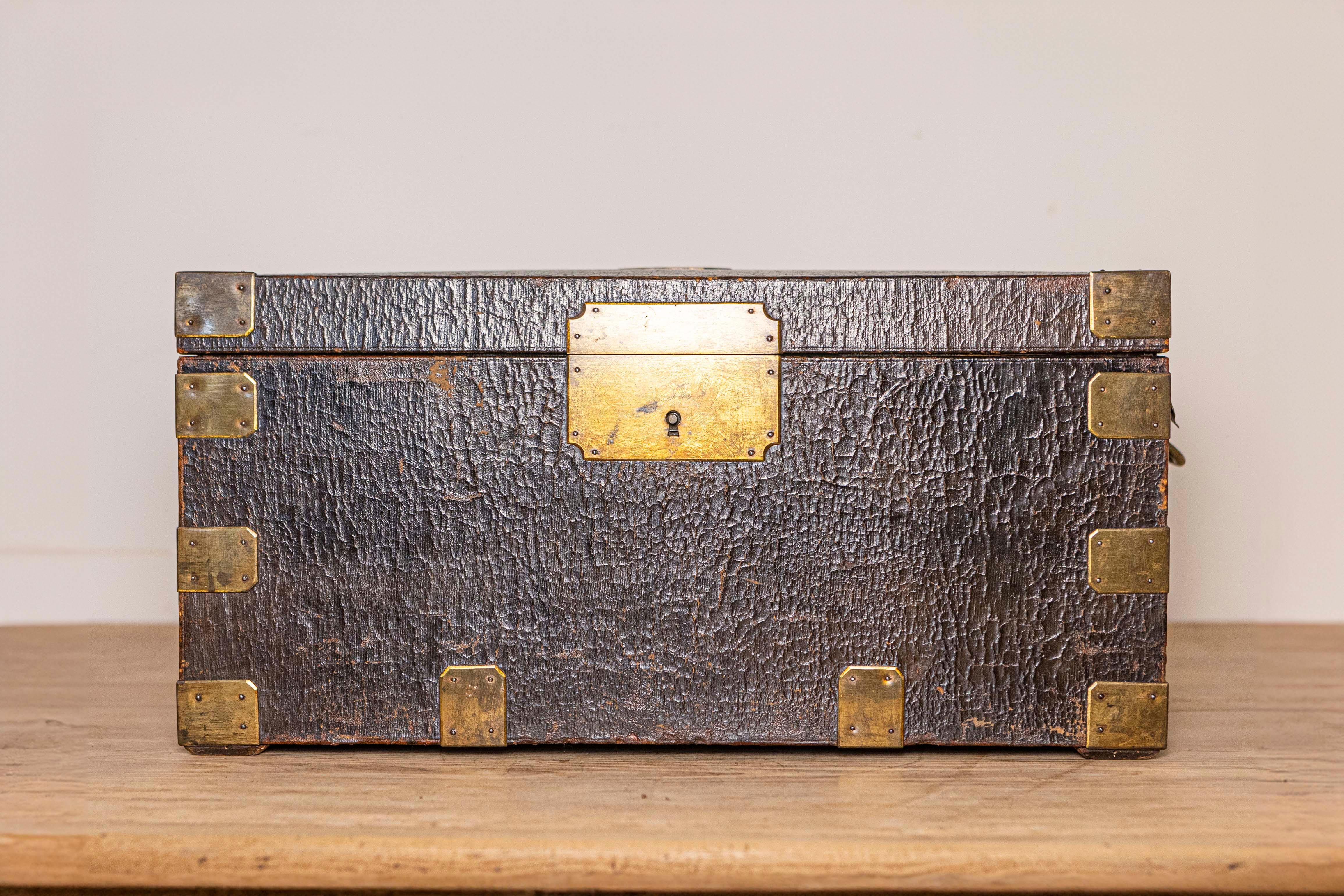 A French wooden decorative box from the 19th century from the Maison 'Gellée Gainier' à la Boule d'Or, Paris, leather bound with brass braces, presenting a compartmented interior and brass lateral handles. Created on the Île de la Cité close to the