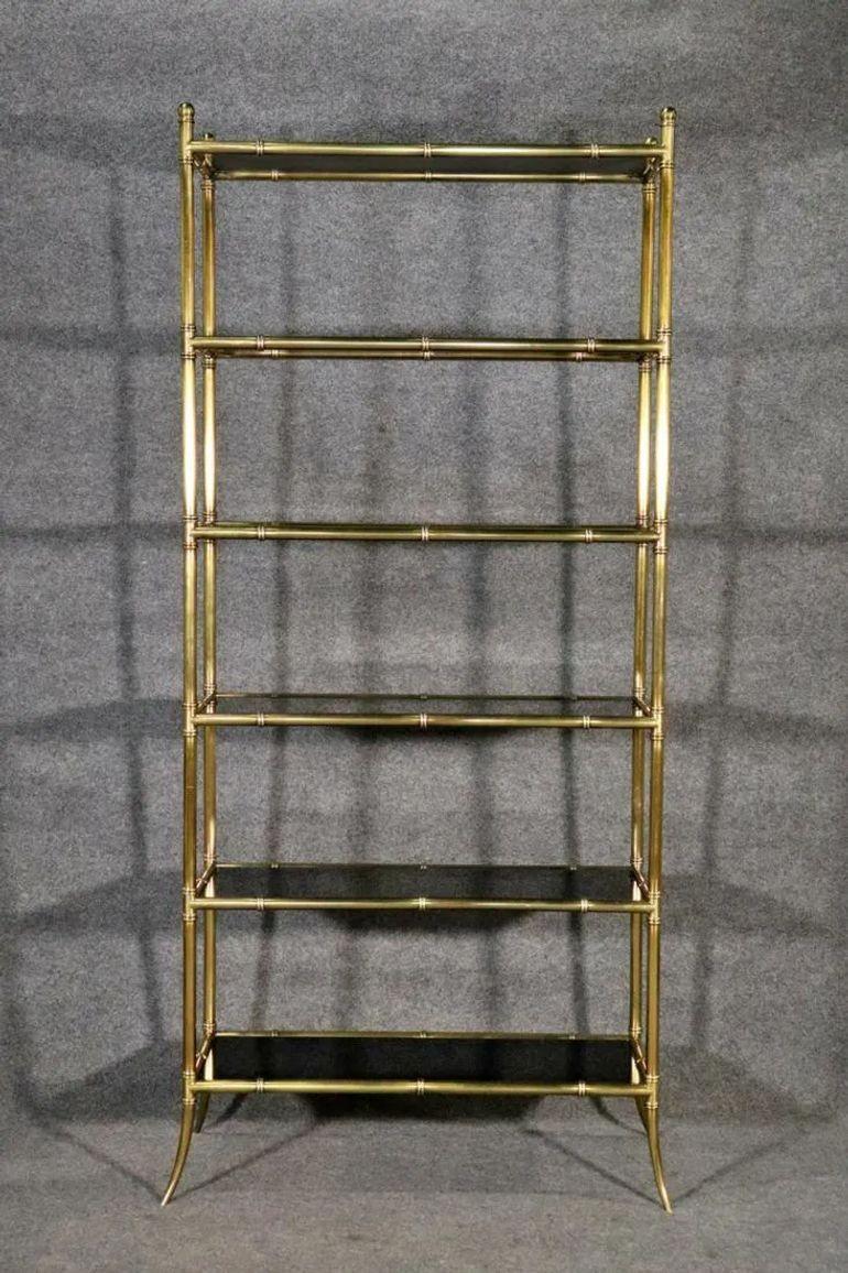 La Maison francese Jansen Manner Elegere con vetro nero e ottone è un pezzo vintage che emana eleganza e raffinatezza. L'etagere è stata progettata nello stile della Maison Jansen, nota per i suoi arredi di alta qualità. I ripiani in vetro nero