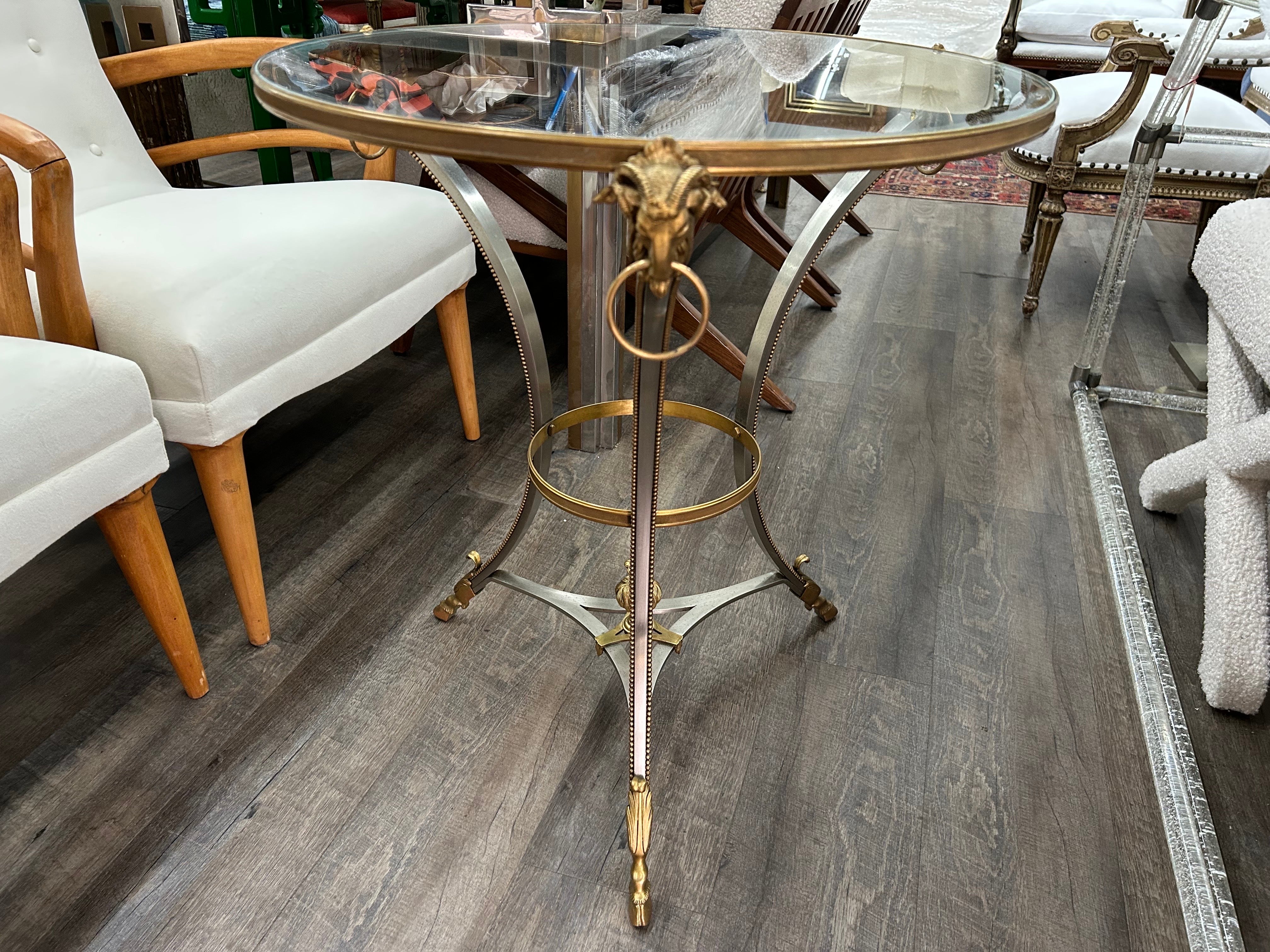 Gueridon en acier et laiton de la Maison Jansen
Rare et inhabituelle table tripode, table d'appoint ou guéridon en acier inoxydable de la Maison Maison Jansen, datant des années 1970. Chaque pied est orné d'un bourrelet en laiton ou en bronze, de