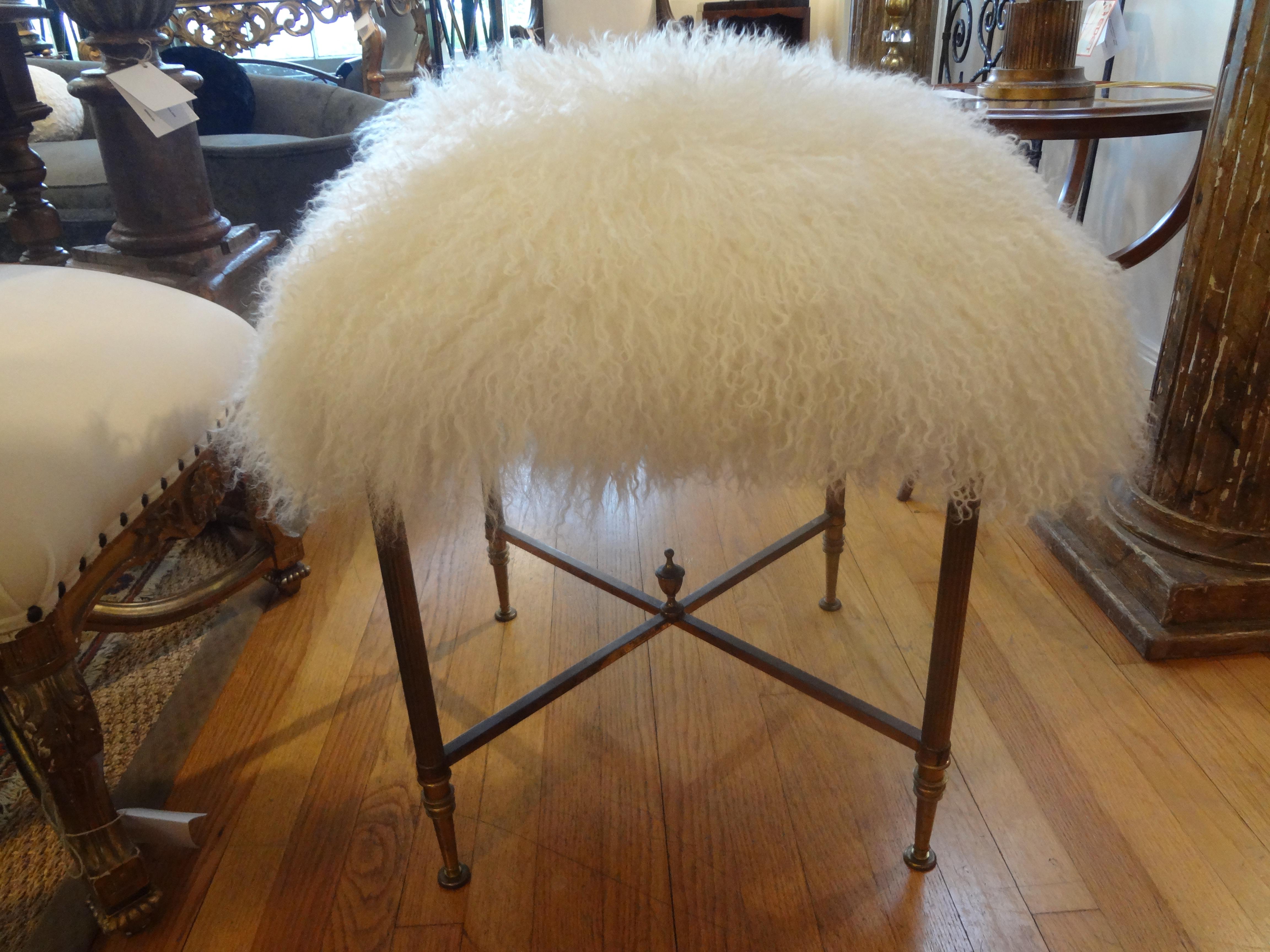 Beautiful, large and comfortable French Maison Jansen inspired brass bench, ottoman or stool newly upholstered in white curly Mongolian lambs wool. A versatile and usable ottoman for extra seating wherever needed. This Hollywood Regency brass bench