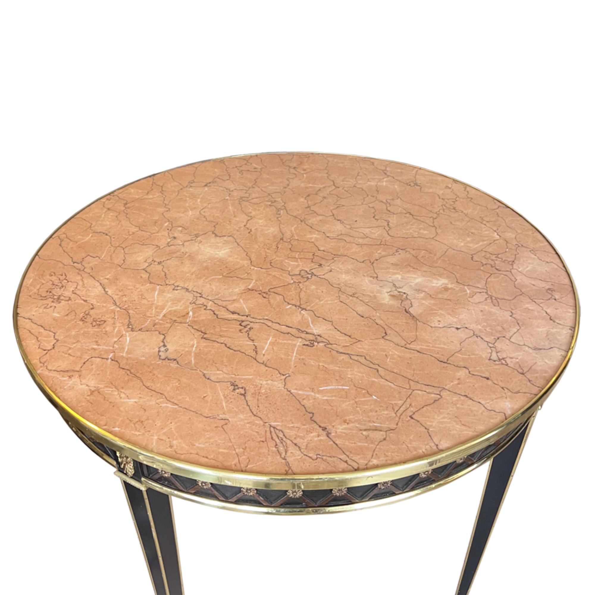 This highly decorative centre table was made in France in the 1950s to a neo classical design and in the style of the luxury designer brand, Maison Jansen. 

It's made with ebonised wood and a beautiful marble top - with brass detailing and a