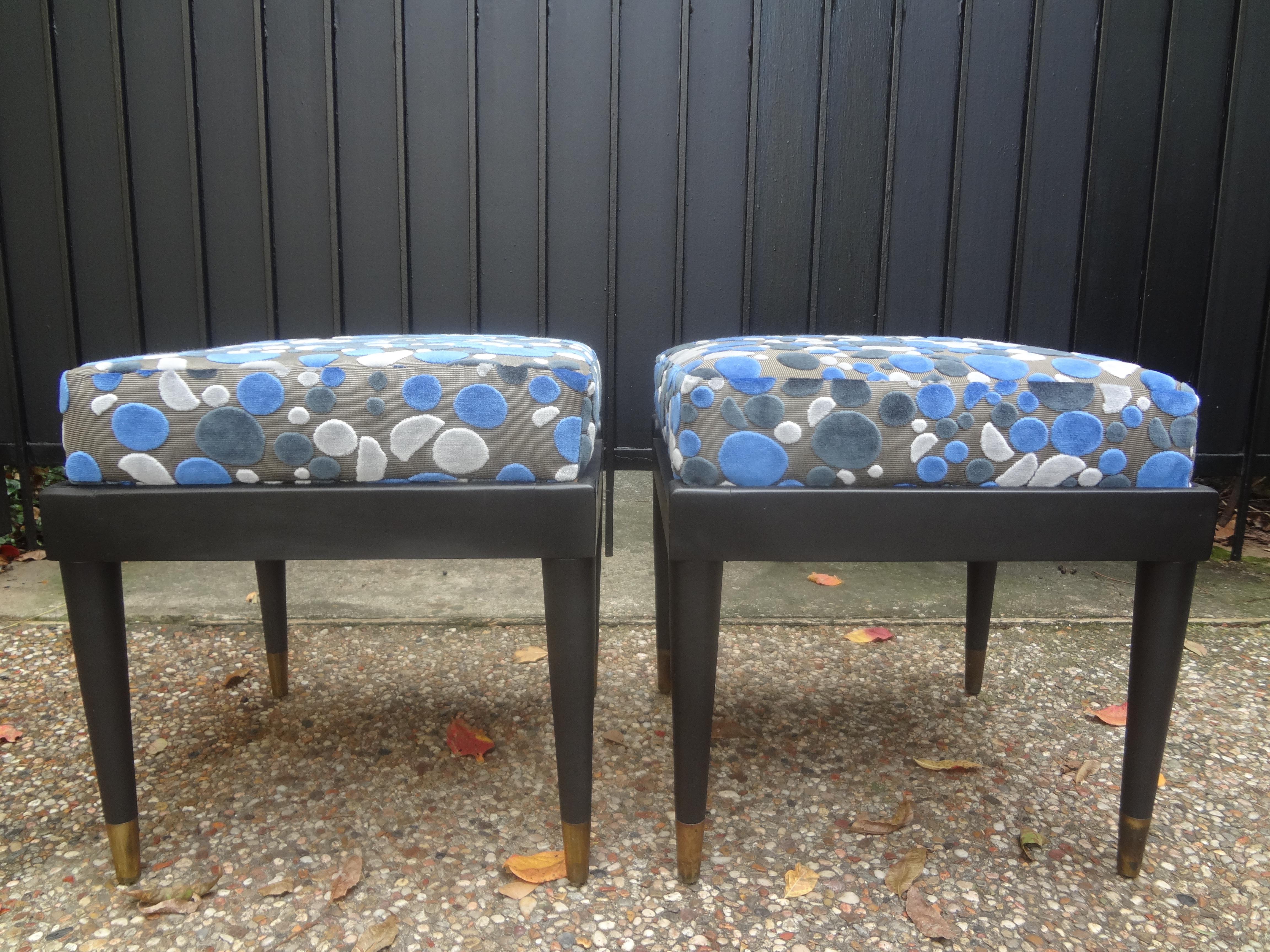 Pair of French Louis XVI style ottomans after Jansen. These stunning French Maison Jansen style ottomans, benches or stools have a matte ebonized finish, tapered legs with brass sabots. These French Mid-Century Modern benches have been newly