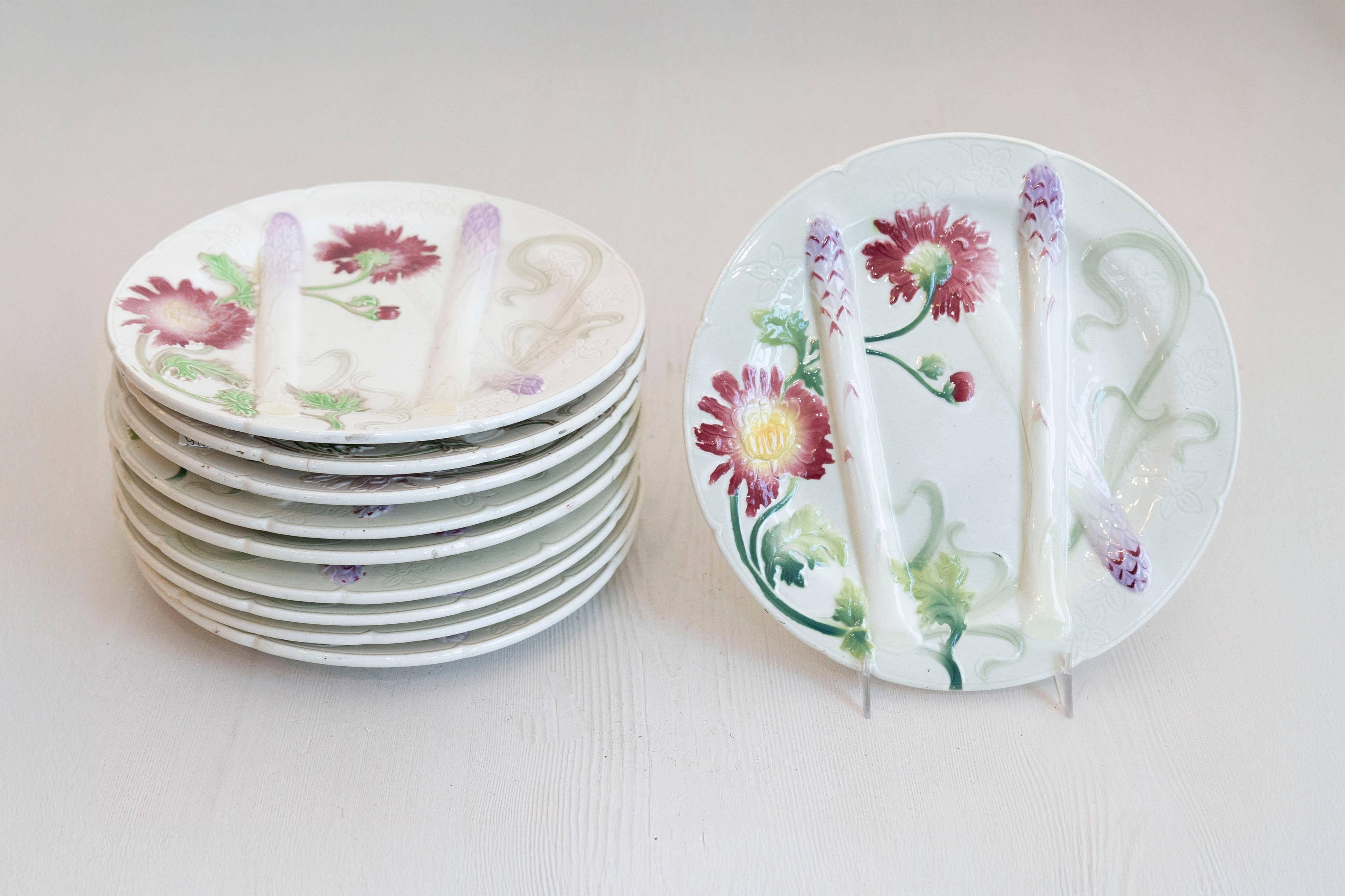 Assiettes à asperges en majolique française du 19e siècle avec des fleurs colorées. Dix assiettes sont disponibles et vendues à l'unité. Nées en France au cours du XIXe siècle, ces assiettes en majolique présentent chacune un délicat décor