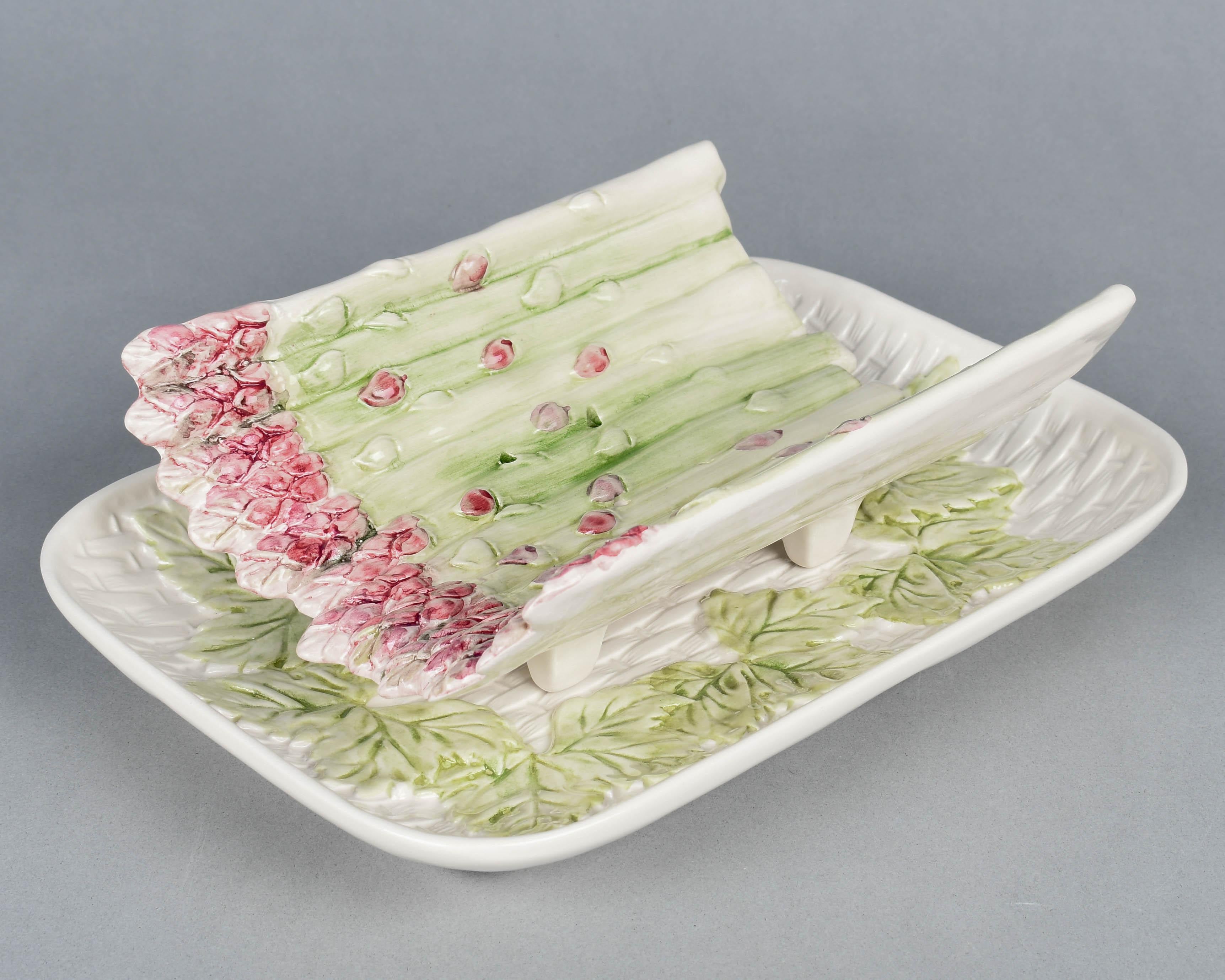 A French Mid Century Majolica asparagus set, hand-panted in pink and light green. Serving cradle with asparagus stalks has a pierced bottom and rests on an rectangular platter with a basketweave pattern and leaf decoration. Circa 1960s
Platter: 12