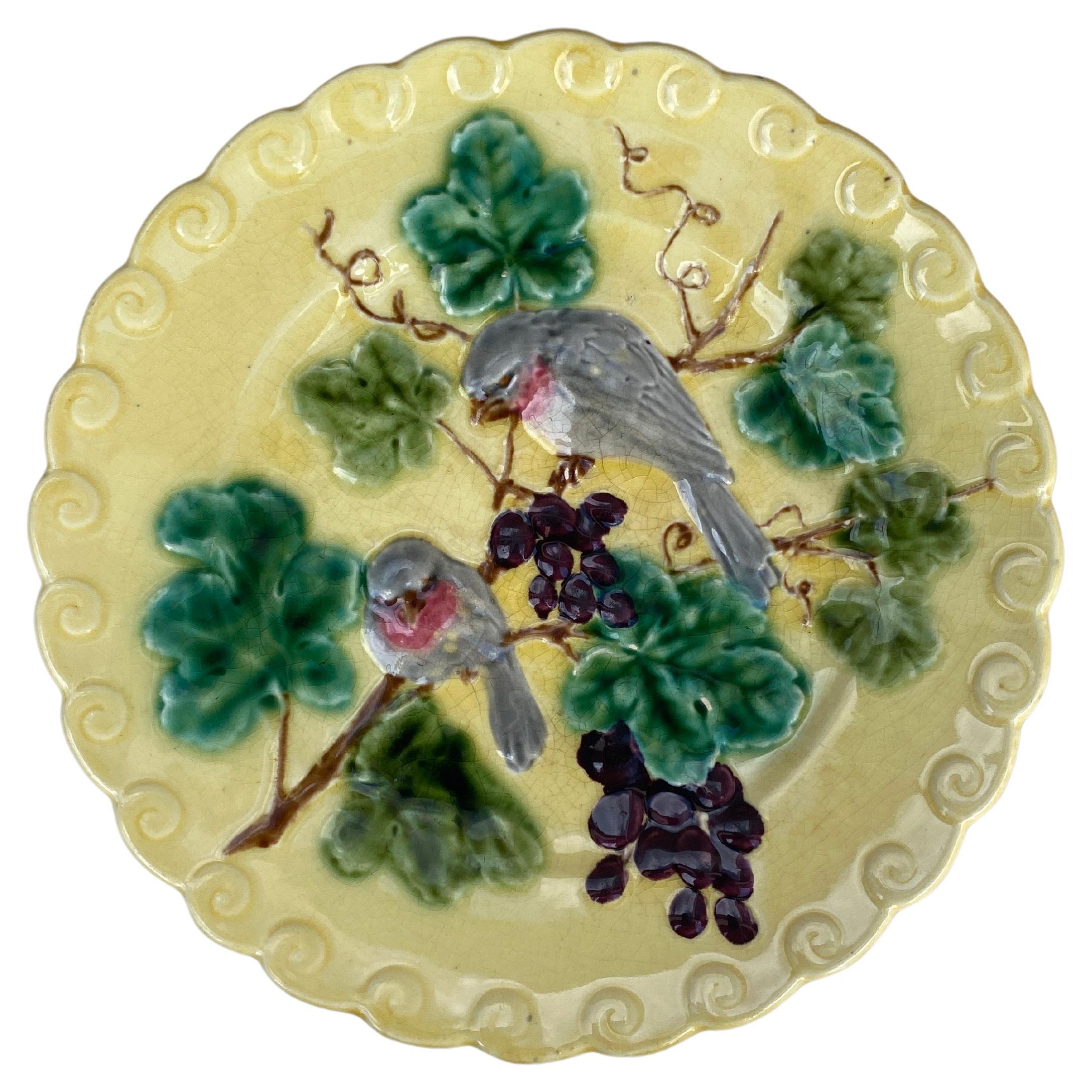 Plato de mayólica francesa con pájaro y acebo firmado Sarreguemines, hacia 1880.