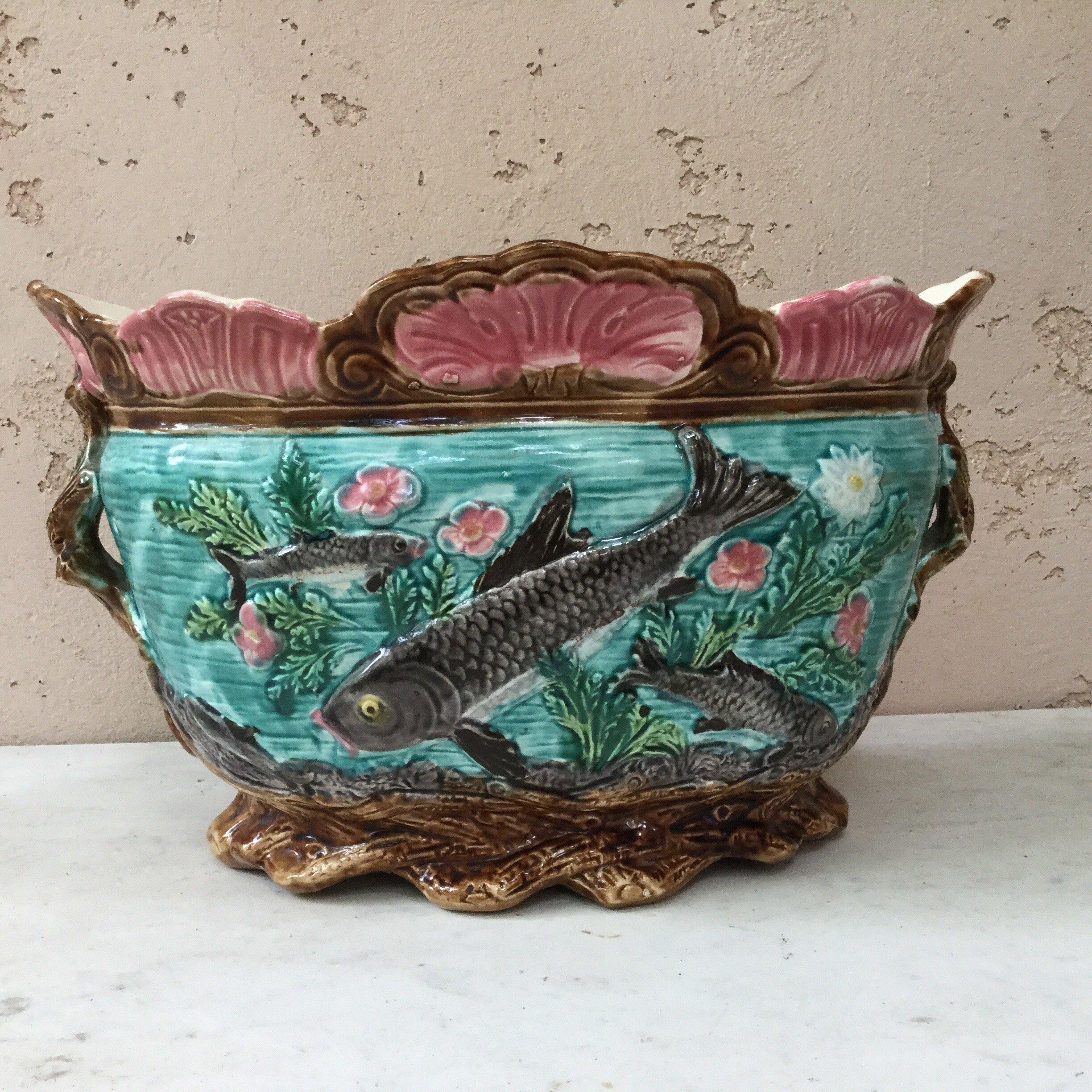 Inspired by the Japonism movement this French Majolica large jardinière is signed Onnaing, circa 1890.
This handled jardinière is decorated with fishes in the water surrounded by seaweeds, the handles and feets are brown branches.