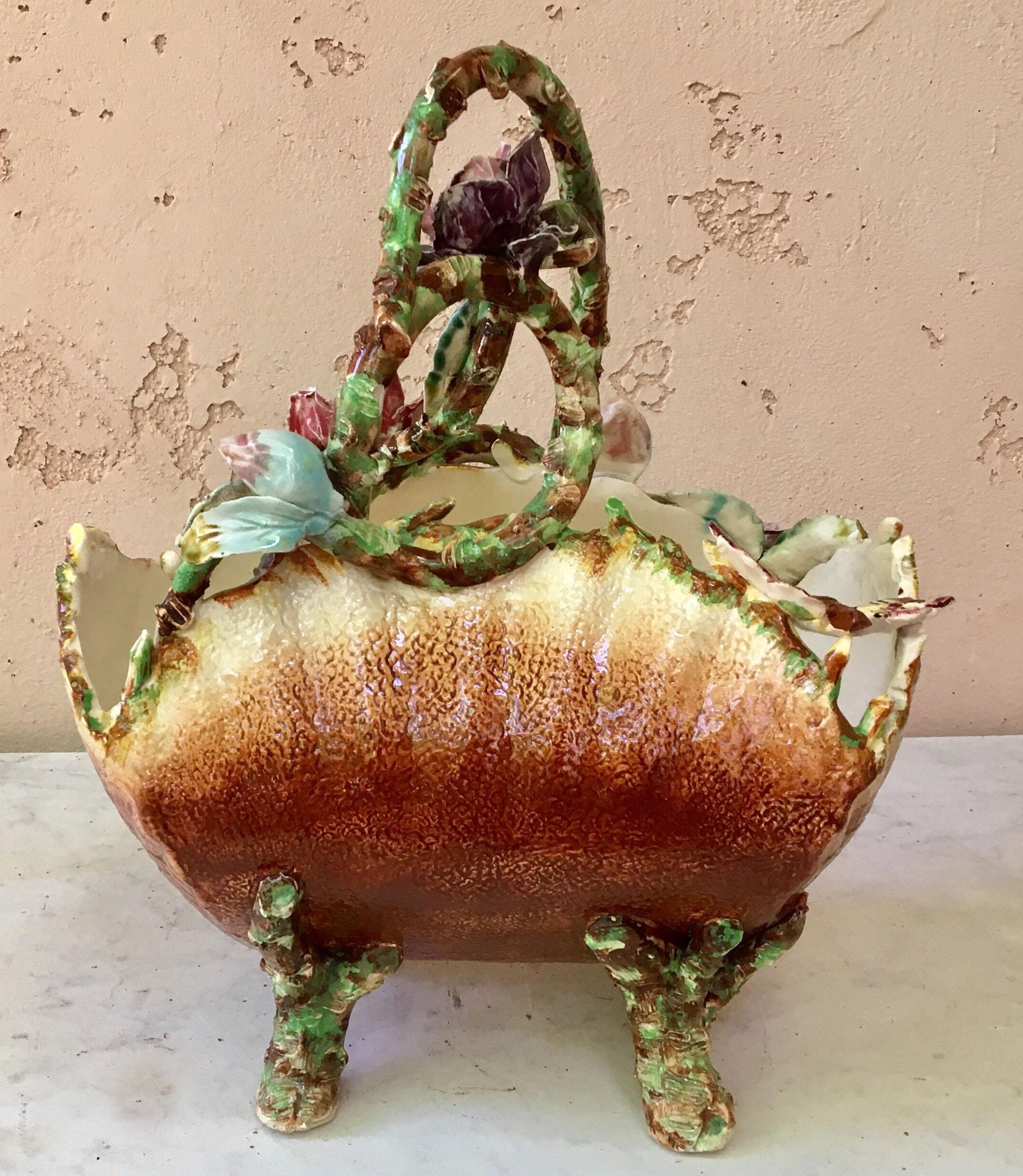 Antique French majolica basket with flowers and butterfly, bug, and insect accents, circa 1880. No maker's mark. Some chips.