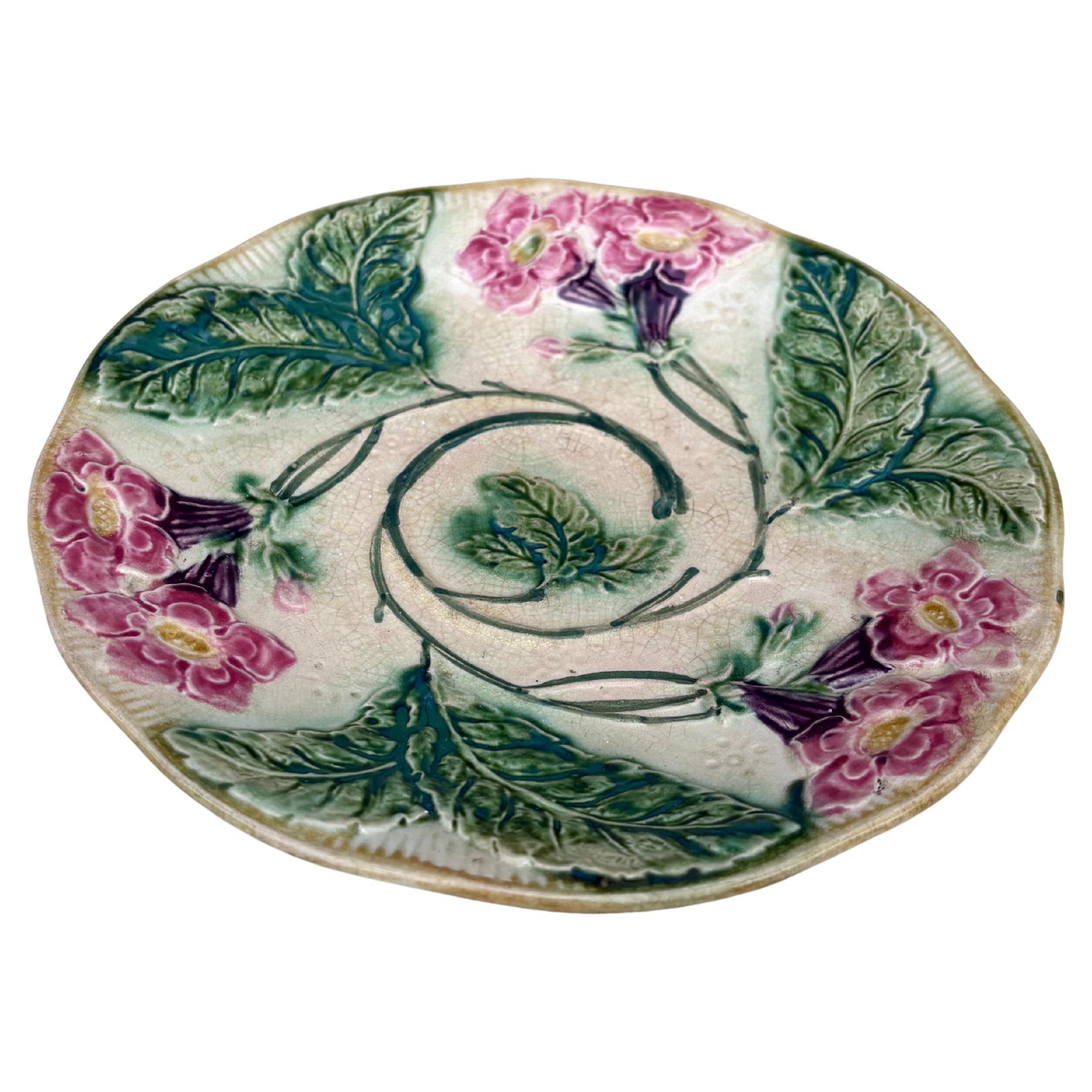 Assiette à fleurs en majolique française Circa 1890.
Décoré de fleurs roses et violettes.