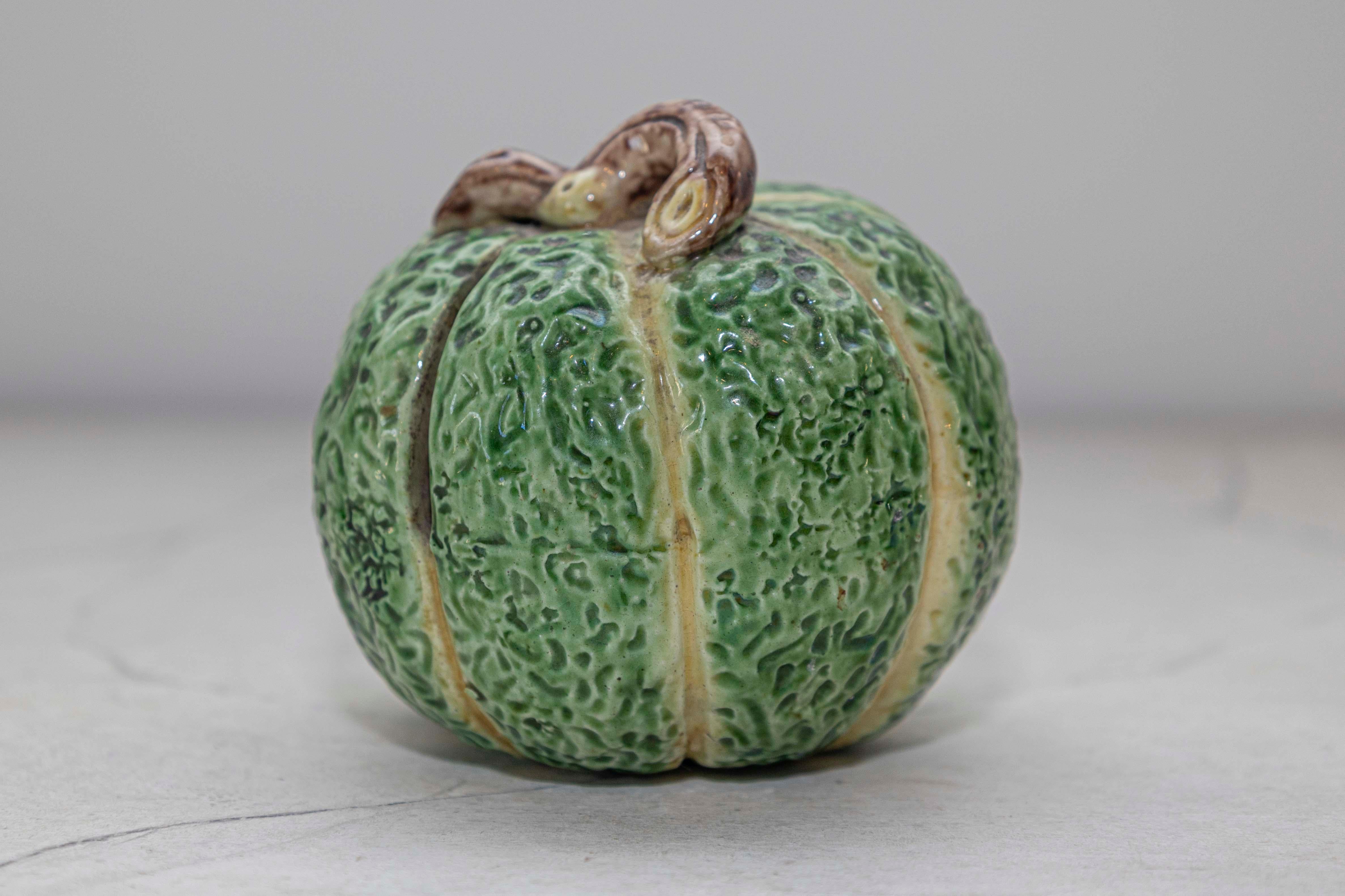 Add a touch of French elegance to your collection with this exquisite Majolica green pumpkin gourd coin bank. Crafted in France, this antique decorative piece is both charming and functional, featuring a realistic green pumpkin gourd design with