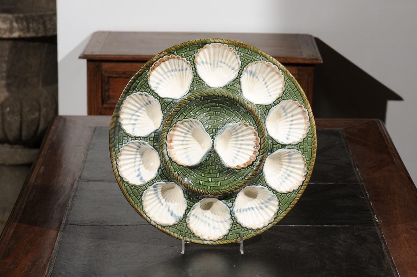 A French majolica Longchamp Terre de Fer scallop platter from the 19th century with green and brown accents. Born in France during the 19th century, this scallop platter presents a green, white and brown décor accented with 12 scallop shells.