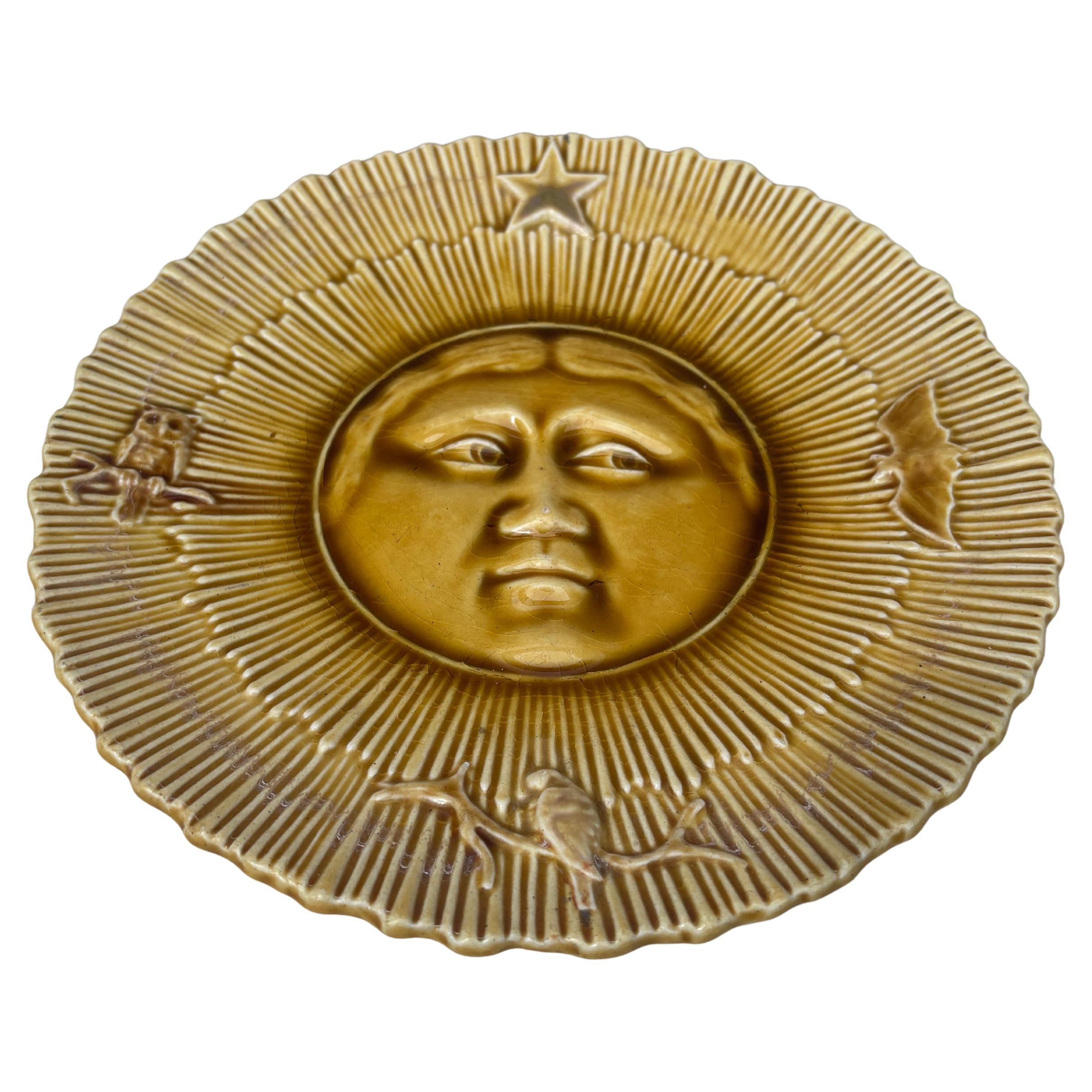 Insolito piatto lunare francese in maiolica gialla con gufo, stella, pipistrello e uccello, circa 1880.
 